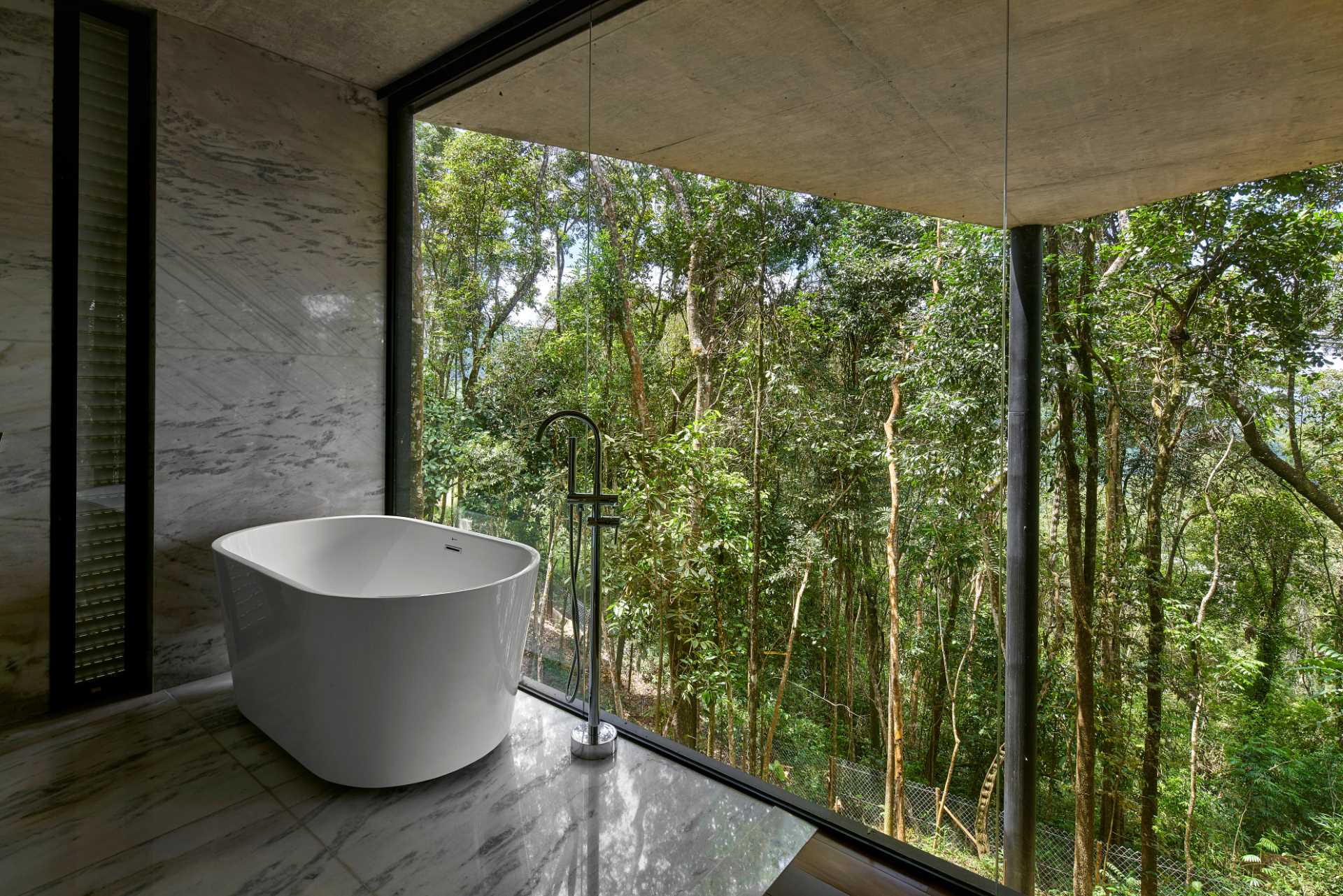 A modern bathroom with floor-to-ceiling windows.