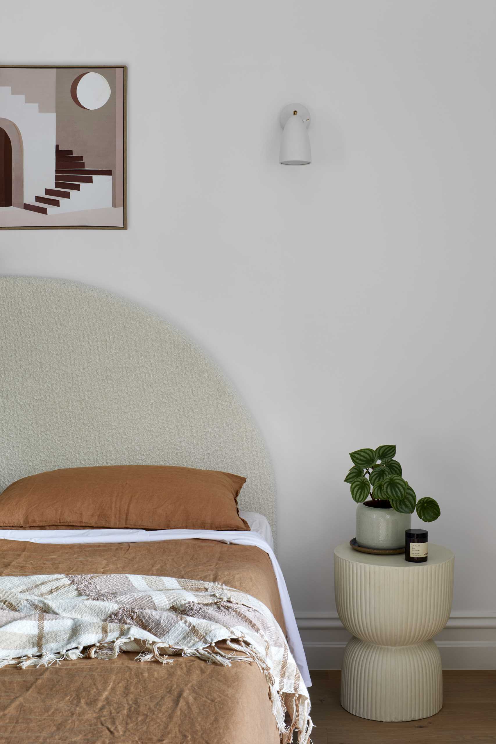Neutral colors keep this modern bedroom relaxing, while a desk has been added in a corner.
