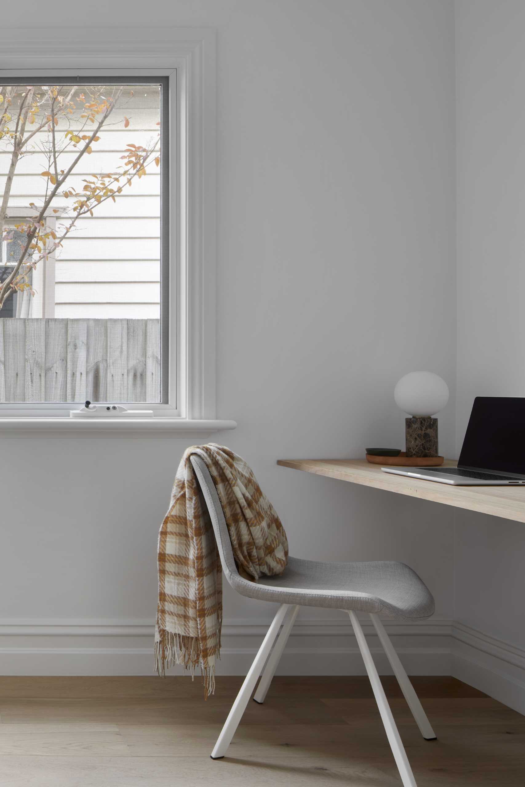 Neutral colors keep this modern bedroom relaxing, while a desk has been added in a corner.