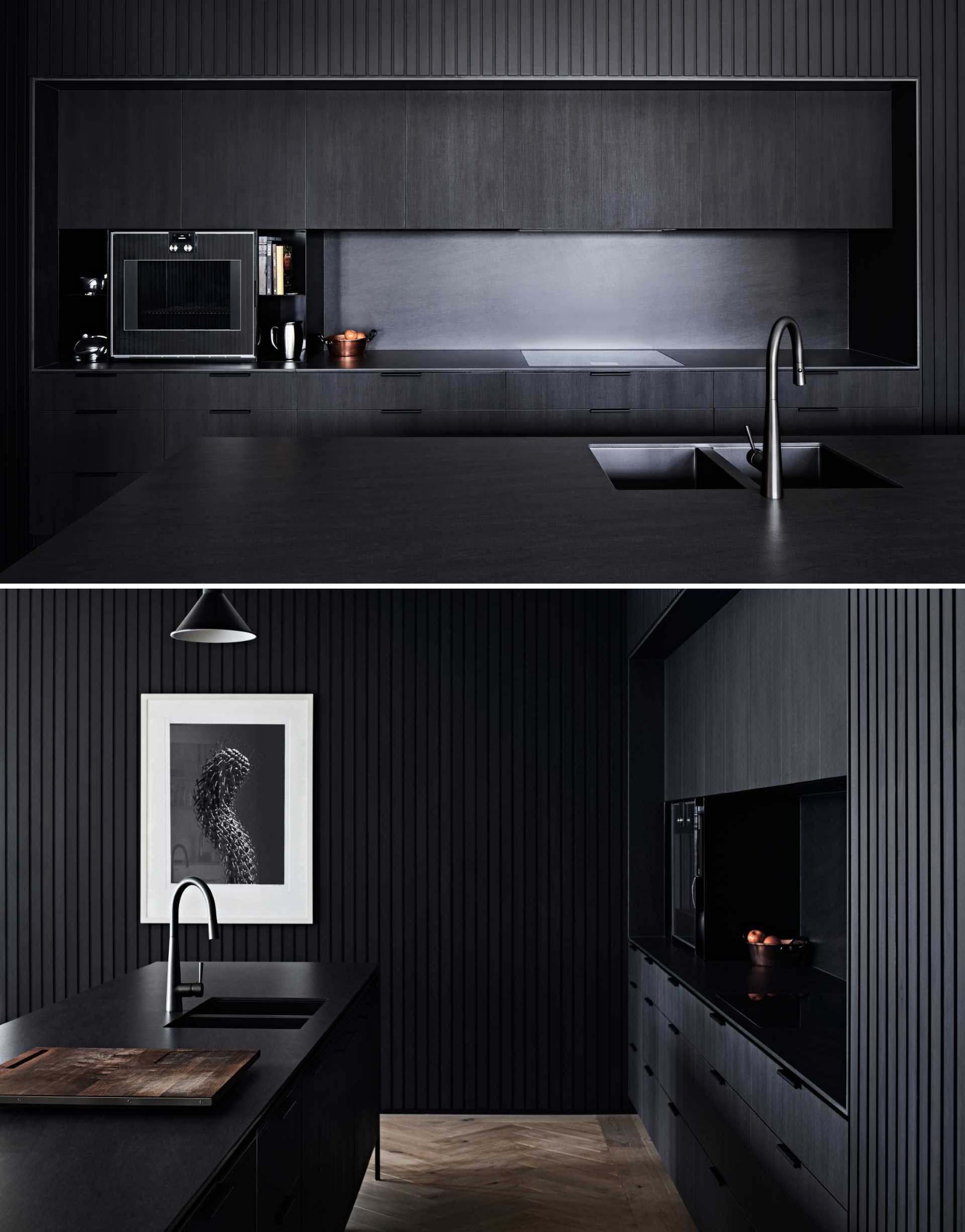 The striking black kitchen facilitates the owners’ love for cooking and entertaining and includes hardware-free cabinets, black appliances, black countertops, and a matching long island with black kitchen faucet and sink.