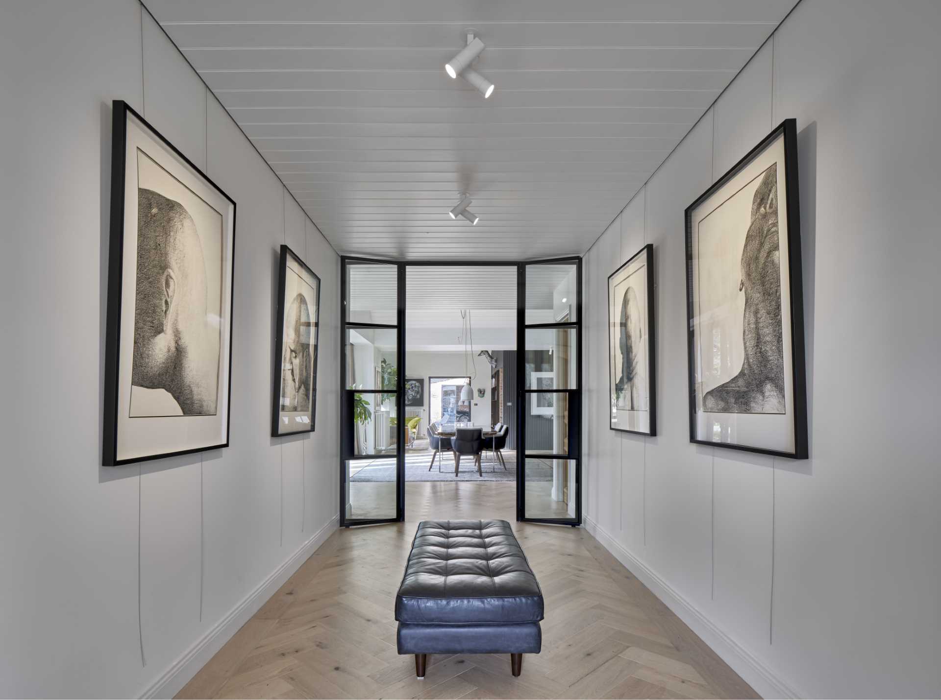 Inside this home, there's engineered timber flooring and white walls filled with artwork.