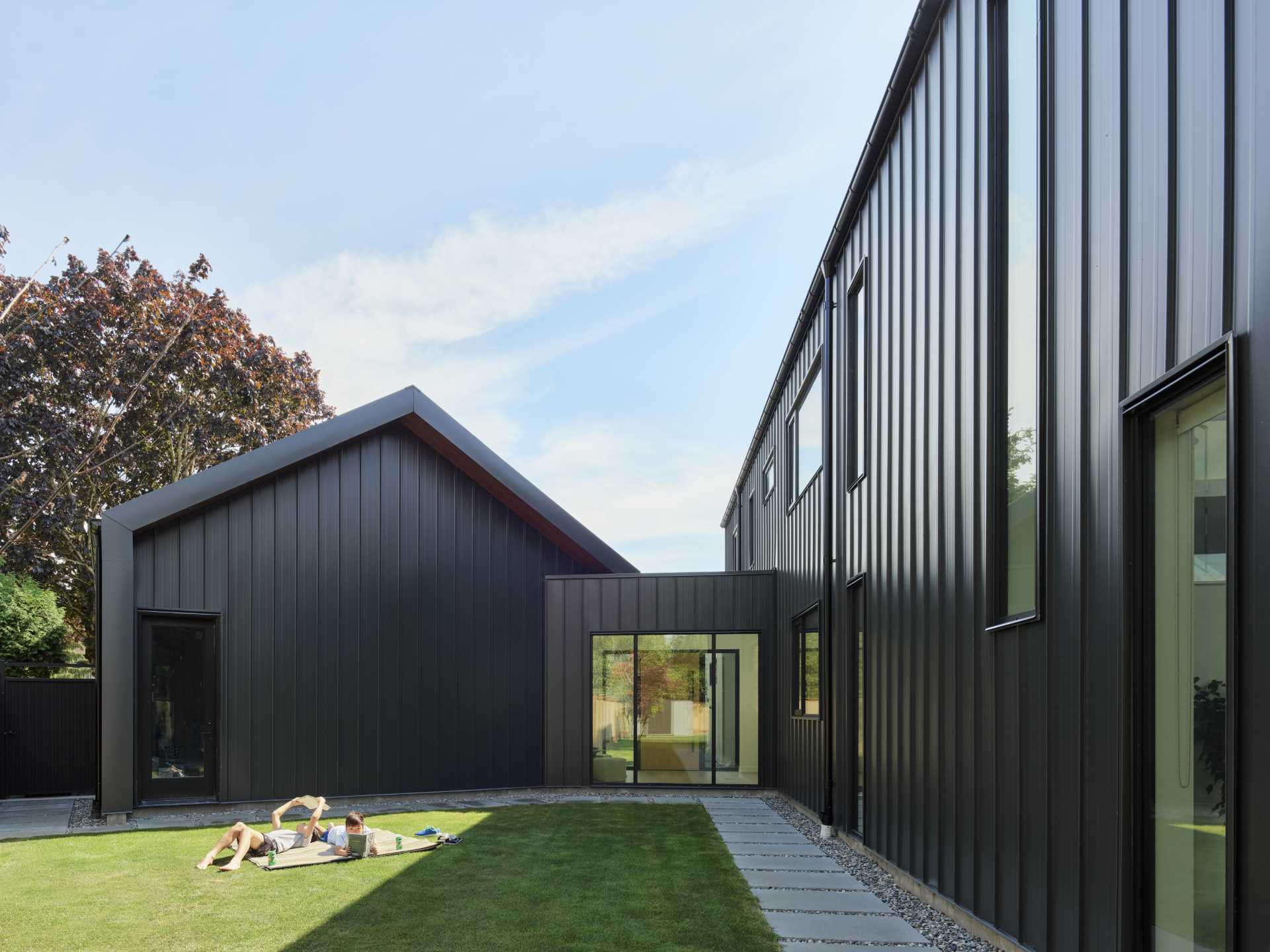 A modern barn house with black siding.