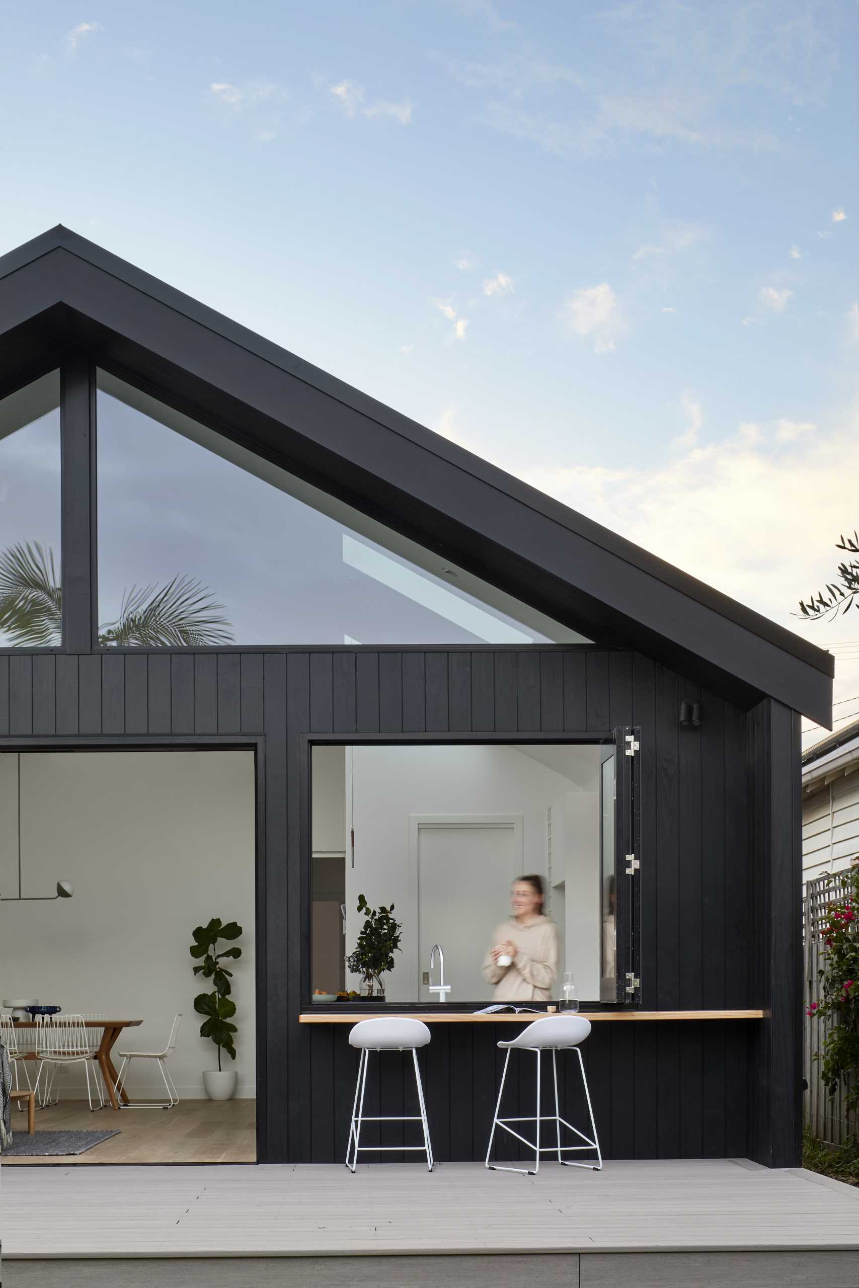 A modern rear house addition that includes a pass-through window.