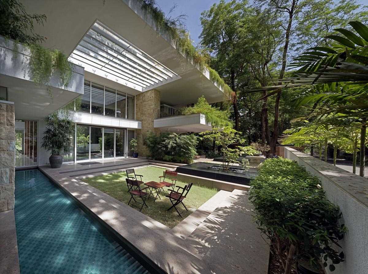 A modern house with overhanging plants that outline the exterior.