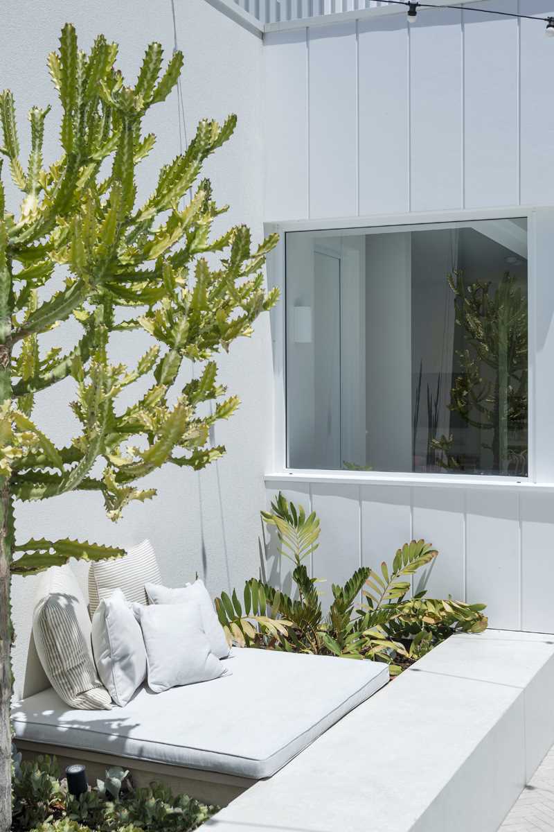Wall surrounding a swimming pool include planters and a seating area.