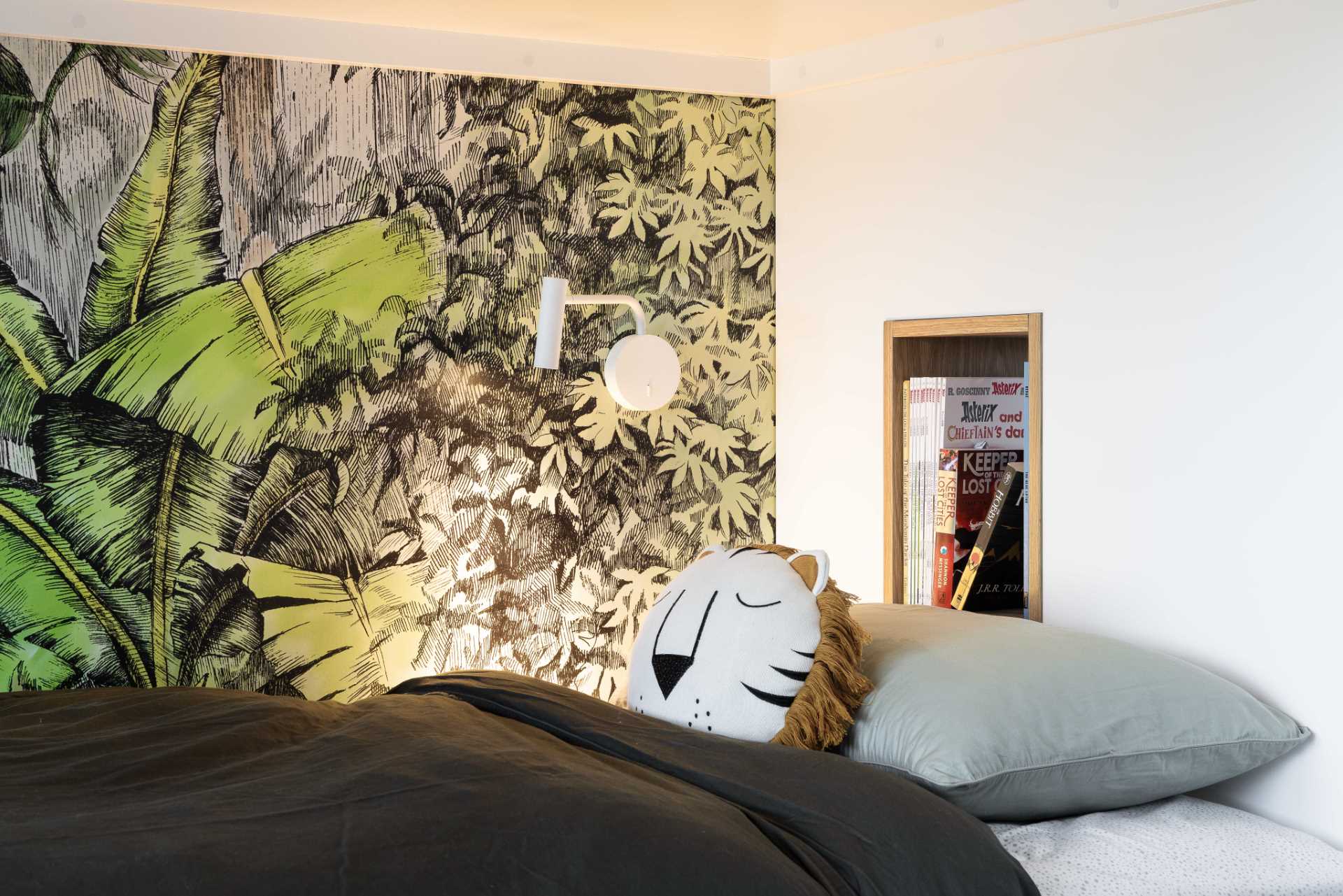 A modern jungle-themed bedroom for two brothers includes bunk beds, rope work, stairs with storage, and tree-top wallpaper.