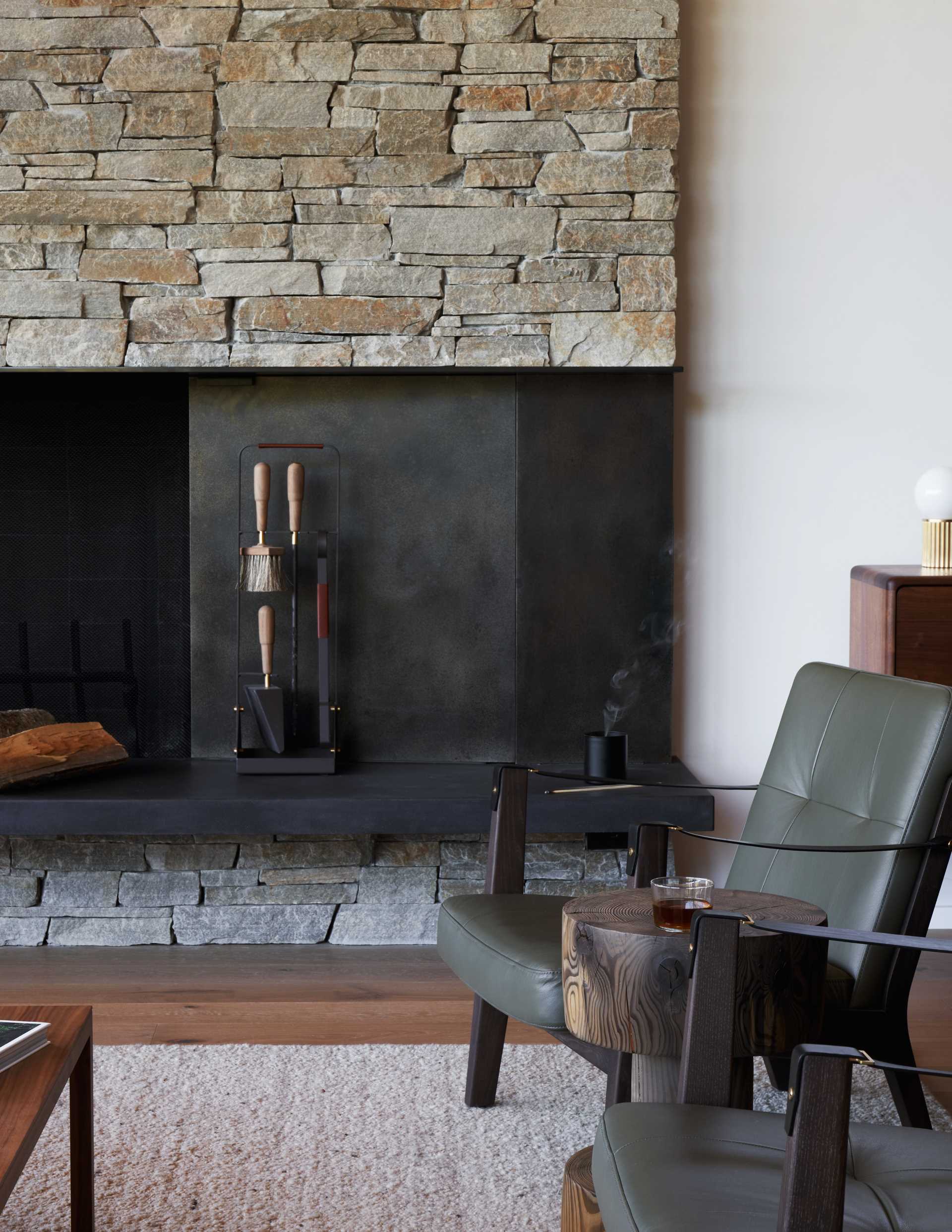 A modern living room with a black and stone fireplace.