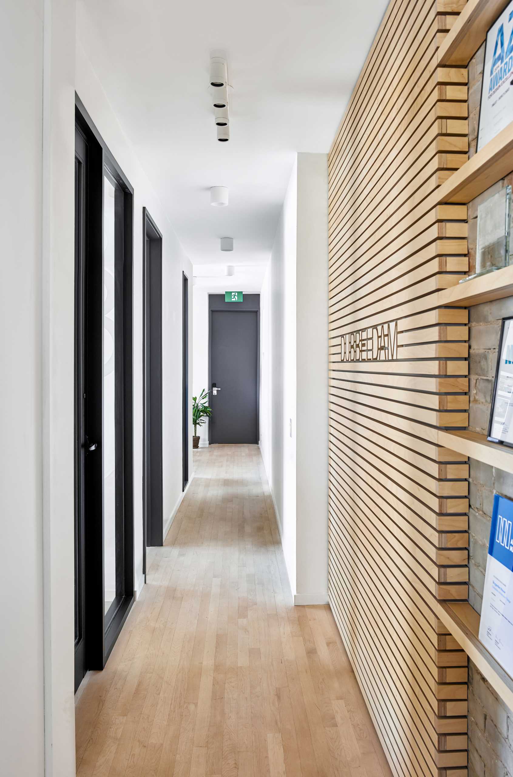 A hallway connects the work area with a kitchen at the other end of the office.