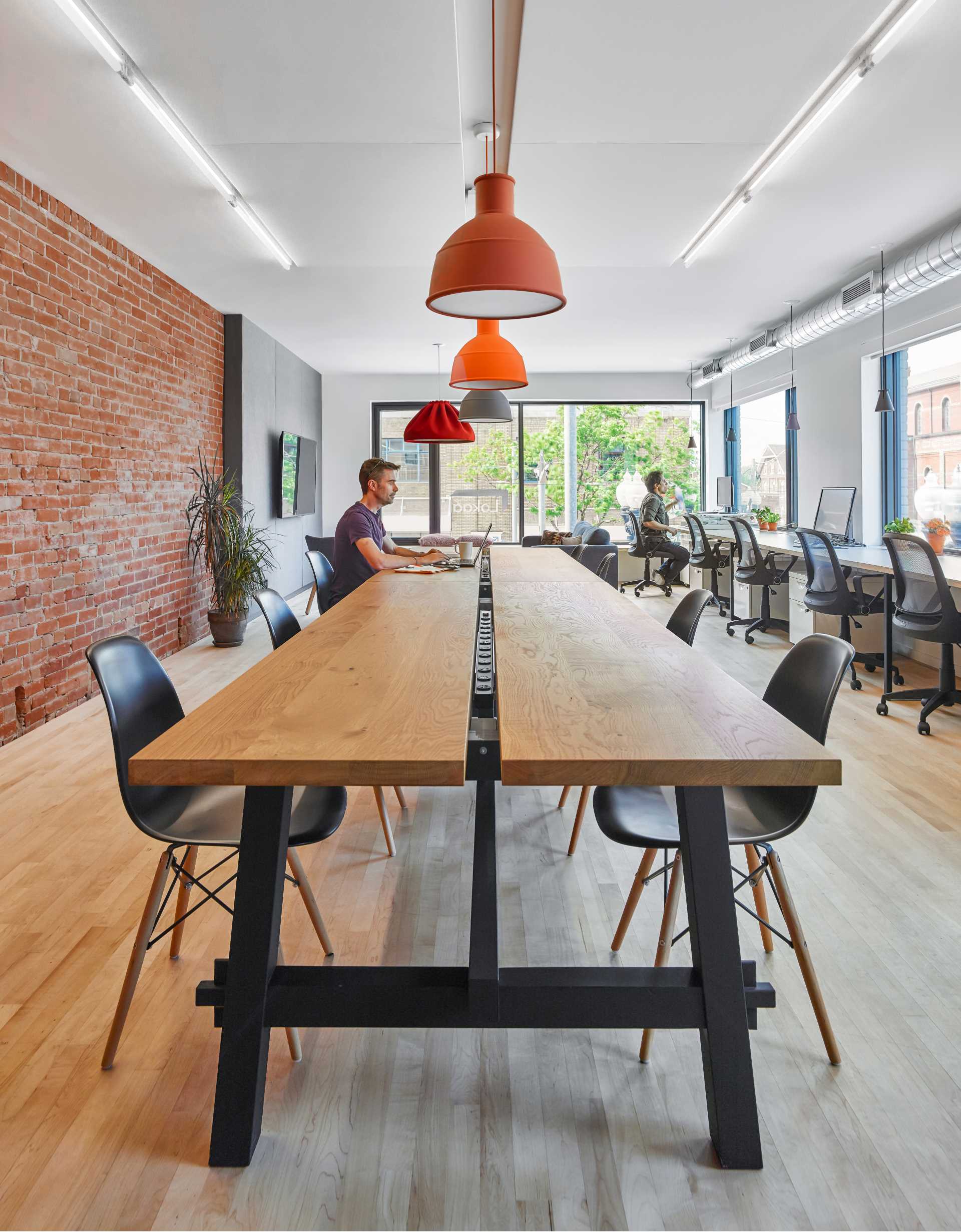 While the crisp white walls and charcoal grey door frames and partitions introduce a bolder graphic quality to the building’s interior, brightly colored light fixtures introduce a degree of playfulness to the Lokaal workspace.