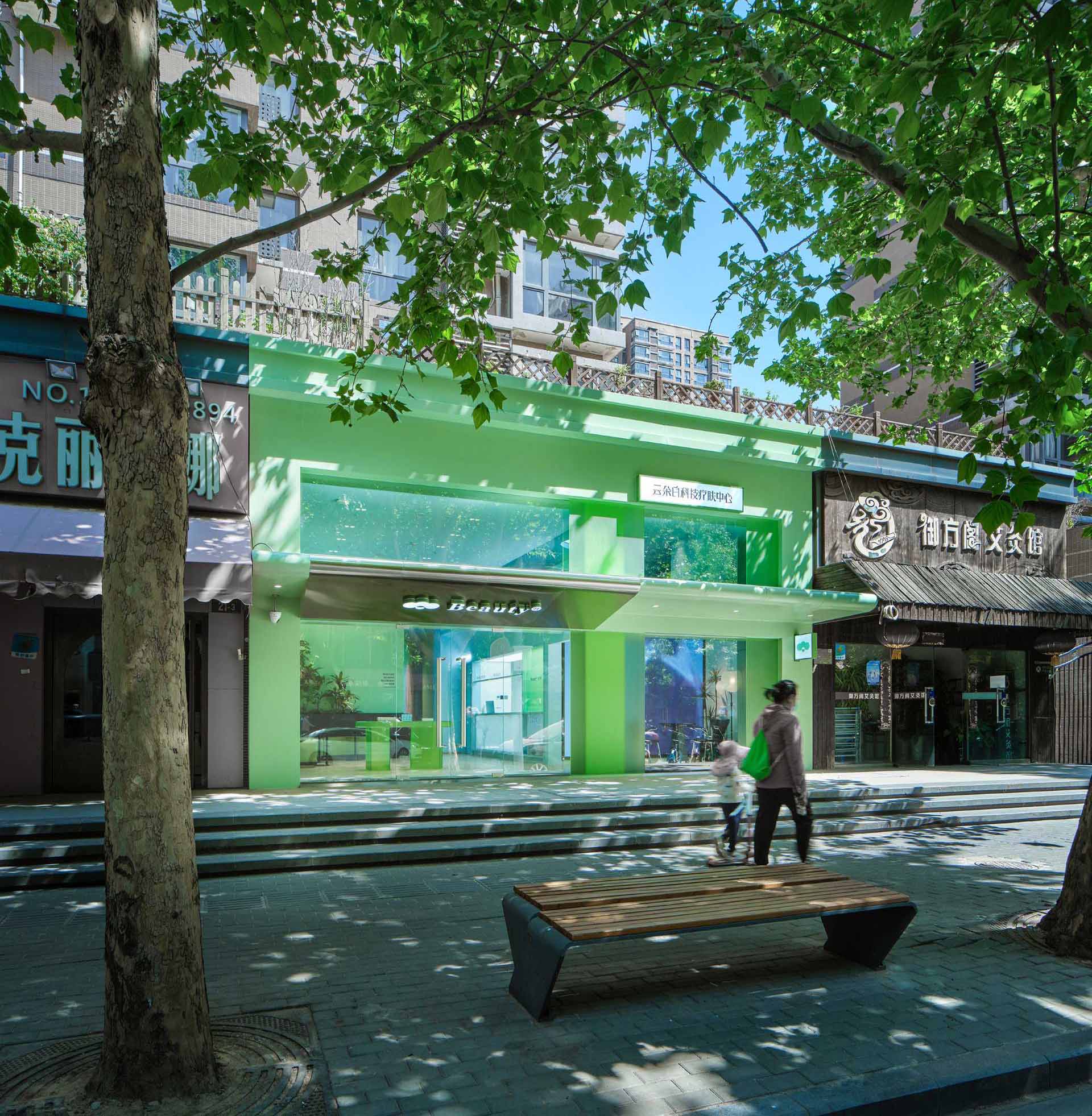 The designers transformed a dark store with a red facade and awning, and transformed it into a bright and open retail design with a green facade and large windows.