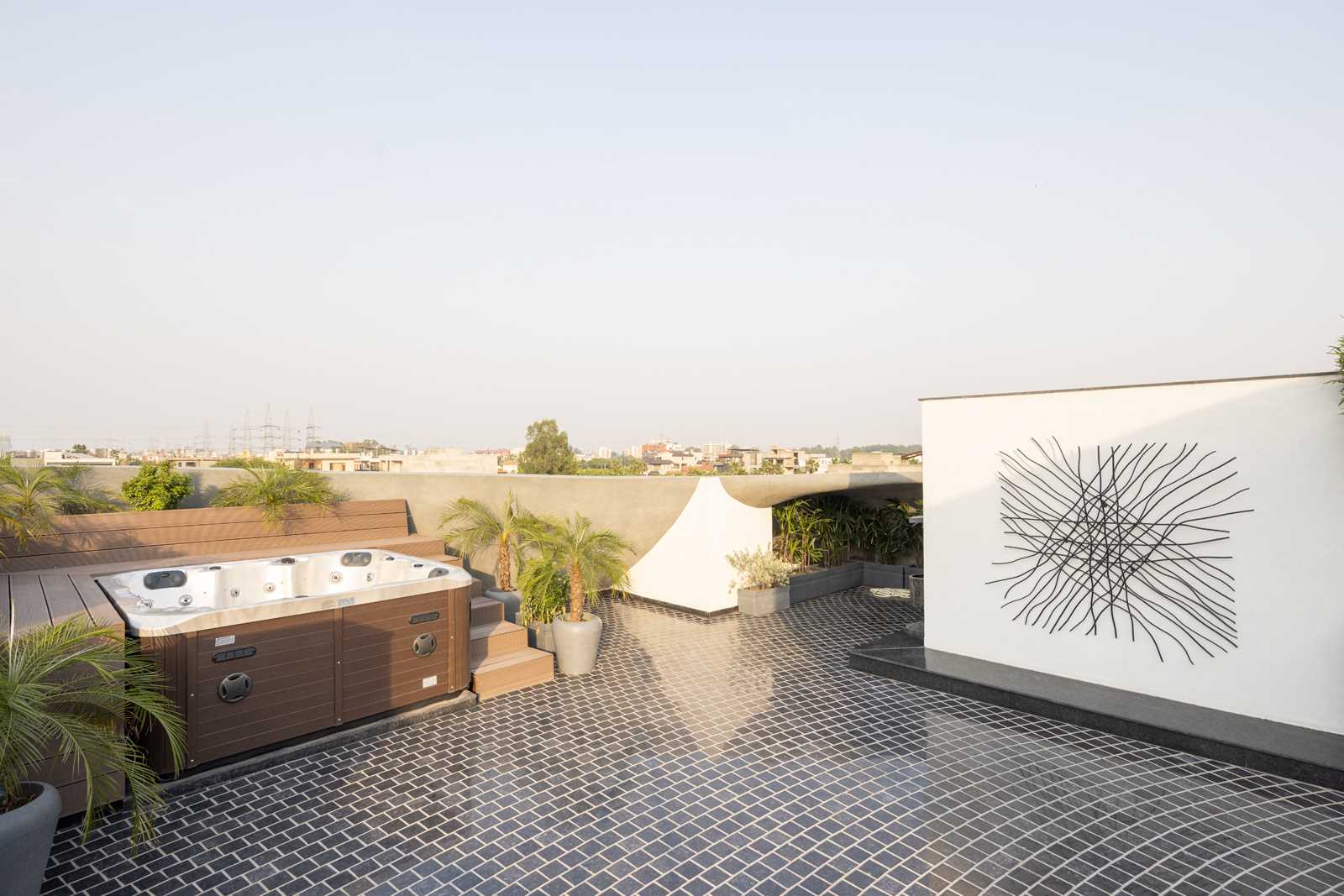 A contemporary rooftop with tile flooring, a hot tub, and seating.
