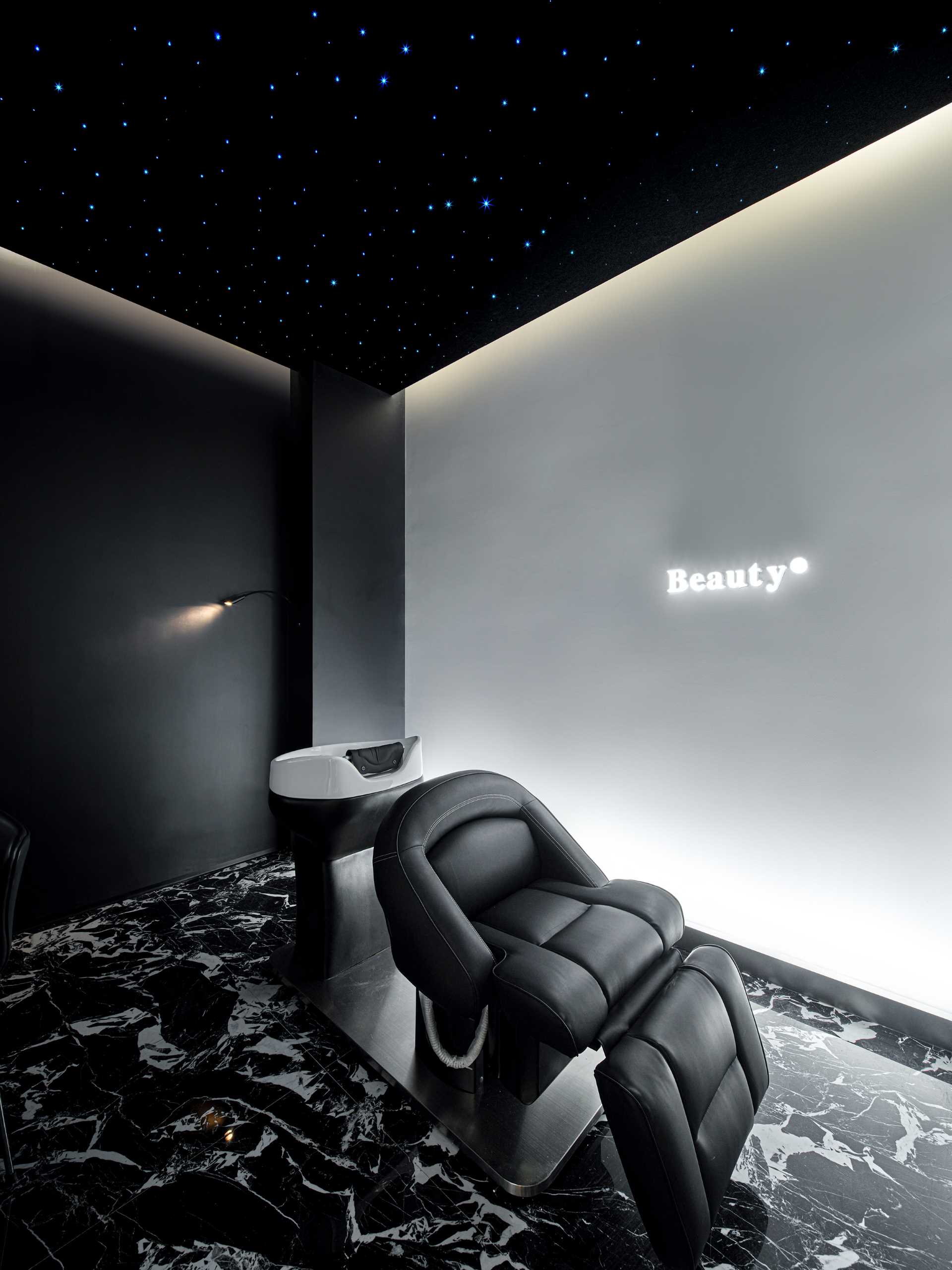 اتاق اسپا سر با سقف آسمان پر ستاره تیره مبله شده است که فضایی آرام و راحت را ایجاد می کند و برای خدمات مراقبت از سر و آرایش ایده آل است.