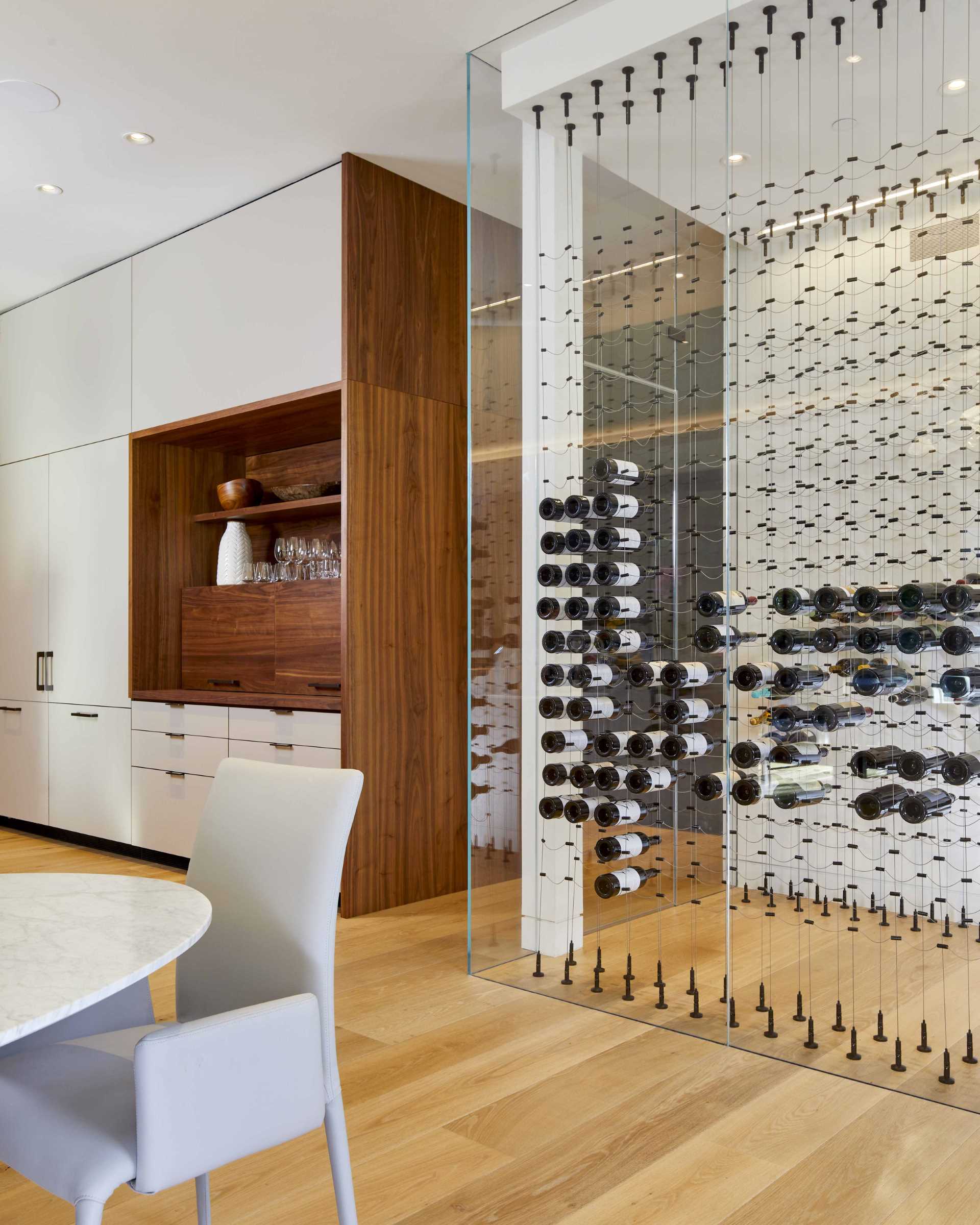 A modern kitchen with a glass-enclosed wine room.