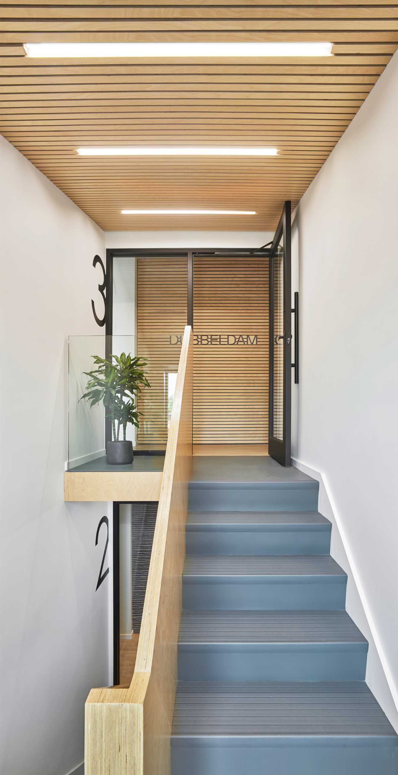The central staircase thematically connects all floors in this office building with Baltic birch slats and graphic floor numbers that lead to Dubbeldam’s top-floor studio.