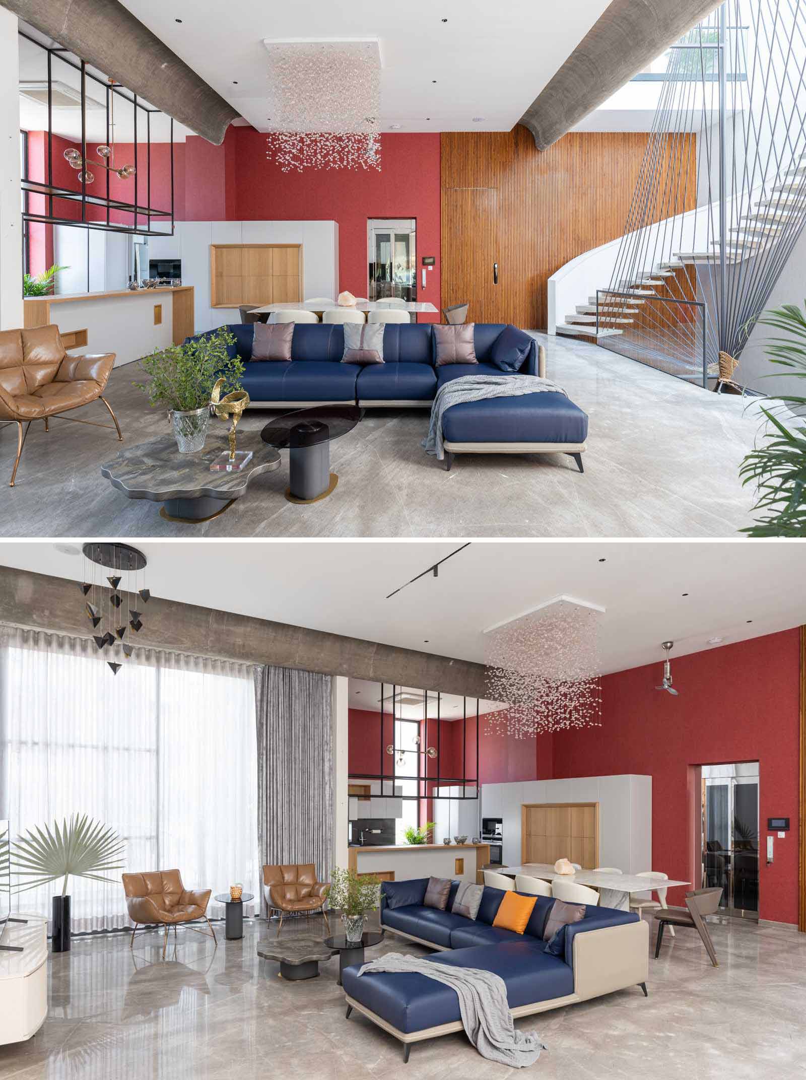 A great room with high ceilings that's home to the living room and dining area. Adjacent to the dining area is the kitchen and a bright red accent wall.