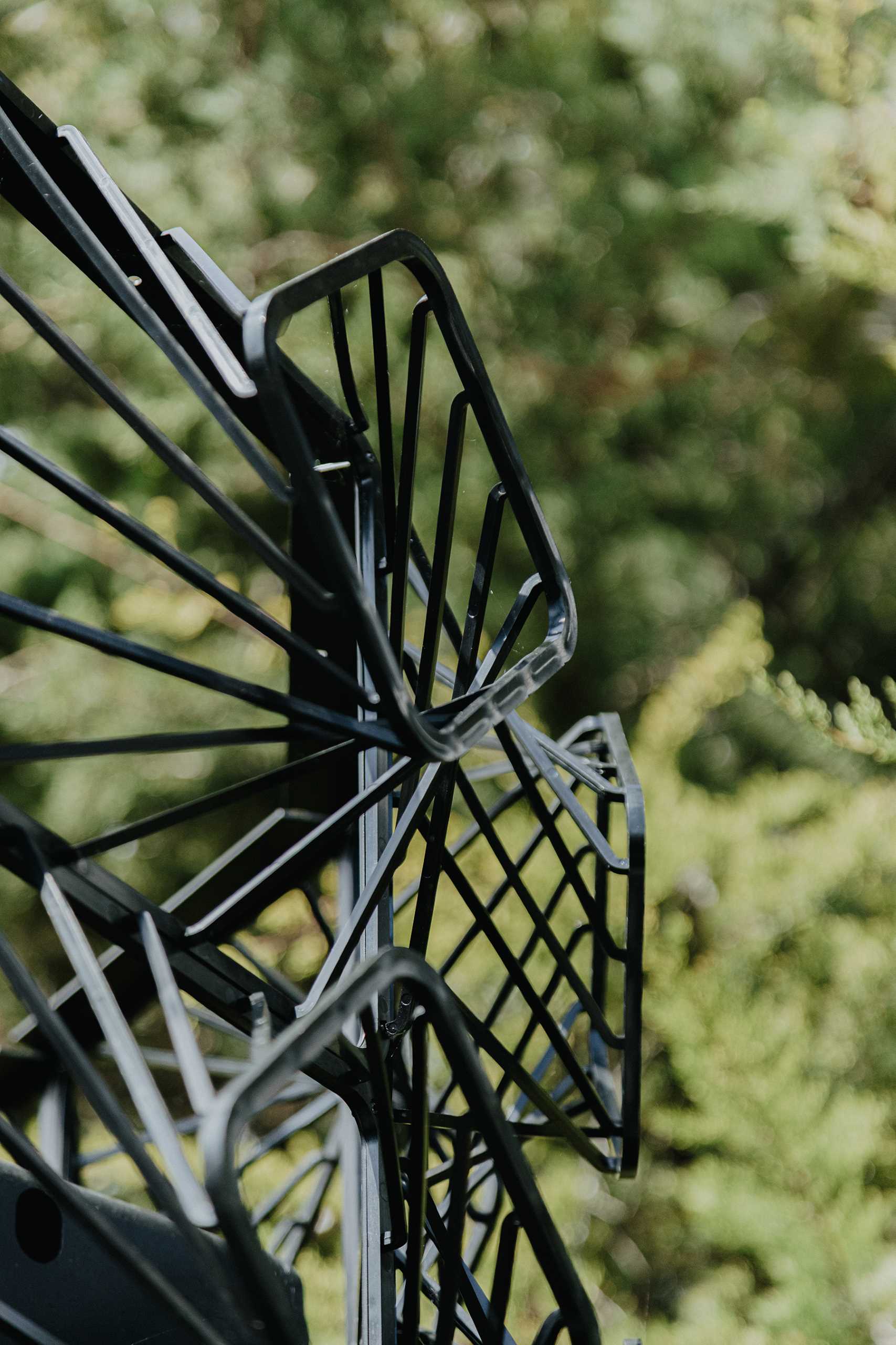 A modern black house with a sculptural facade designed to let plants grow on the exterior over time.