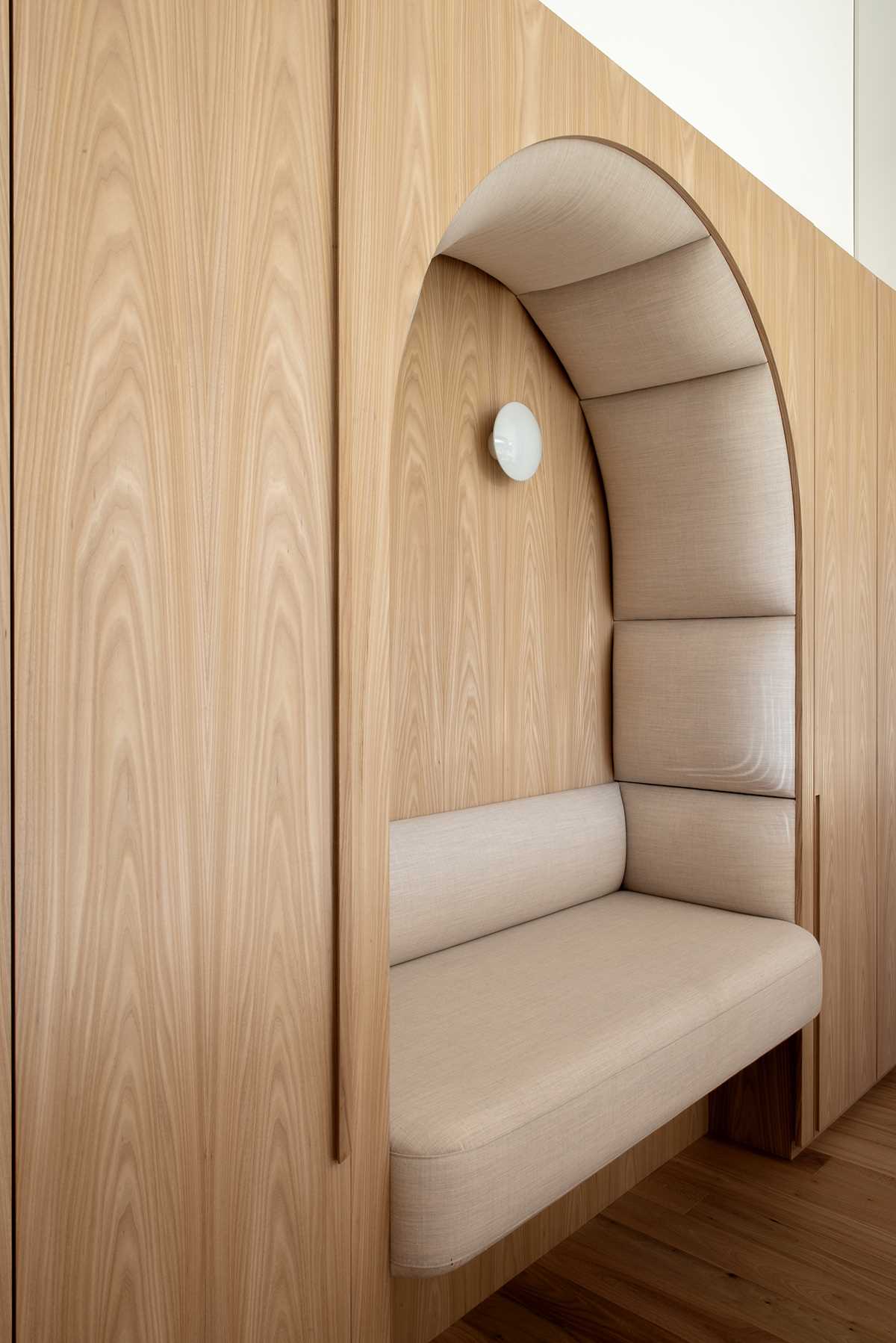 A wall of cabinetry includes a padded built-in bench.