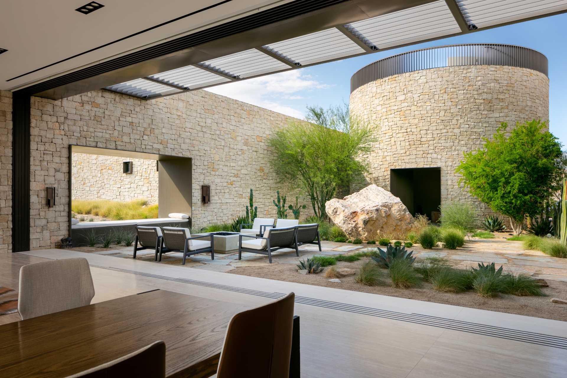 A modern home with a fully-enclosed, shaded courtyard area that's been designed for family meals and gatherings.