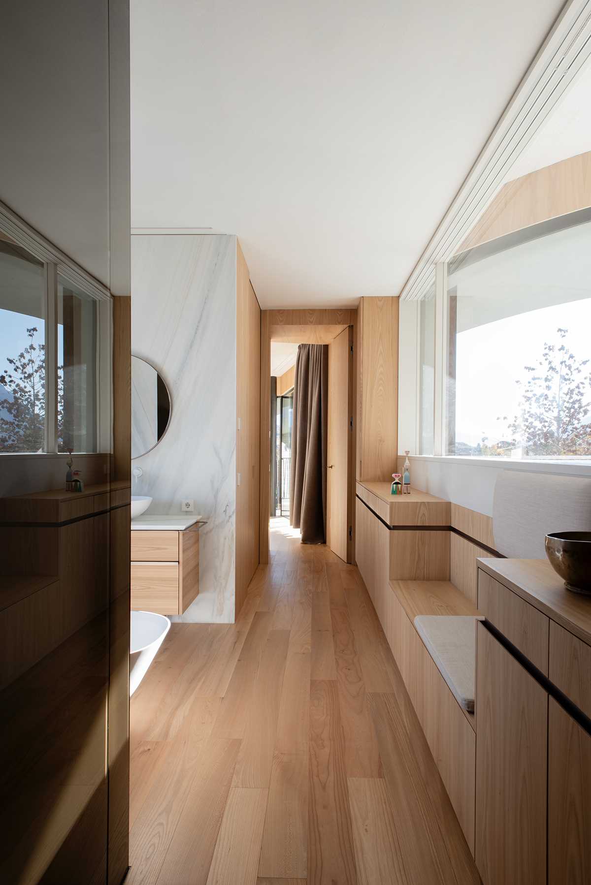 In this modern bathroom, there's built-in cabinetry, a double vanity, and a freestanding bathtub.