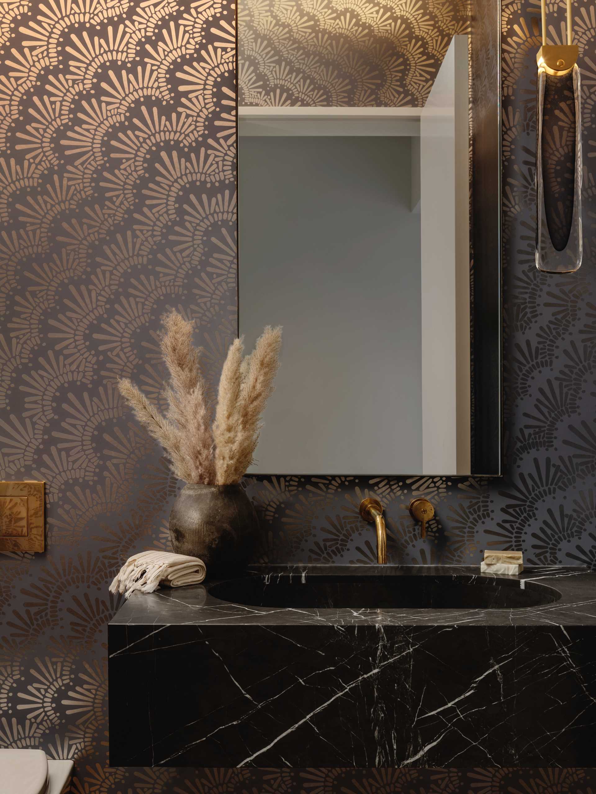 In this bathroom, a fun metallic wallpaper creates a unique look and complements the fixtures.