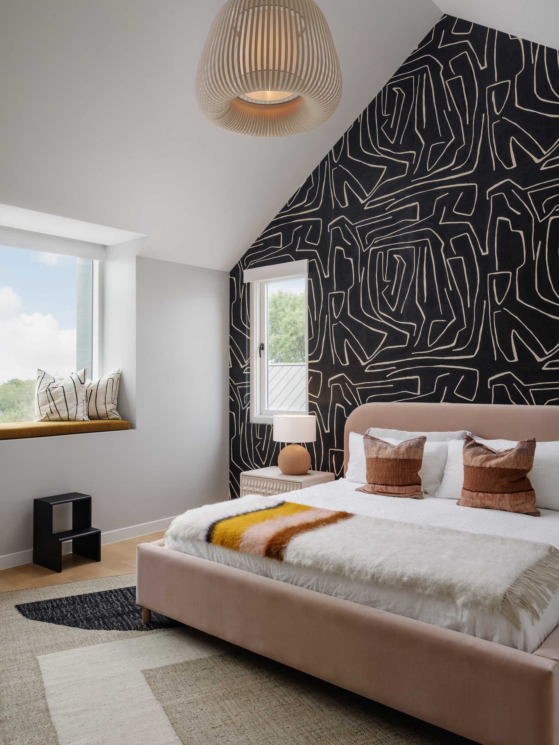 In another bedroom, a graphic wallpaper draws attention, while a window seat provides a view of the city skyline.