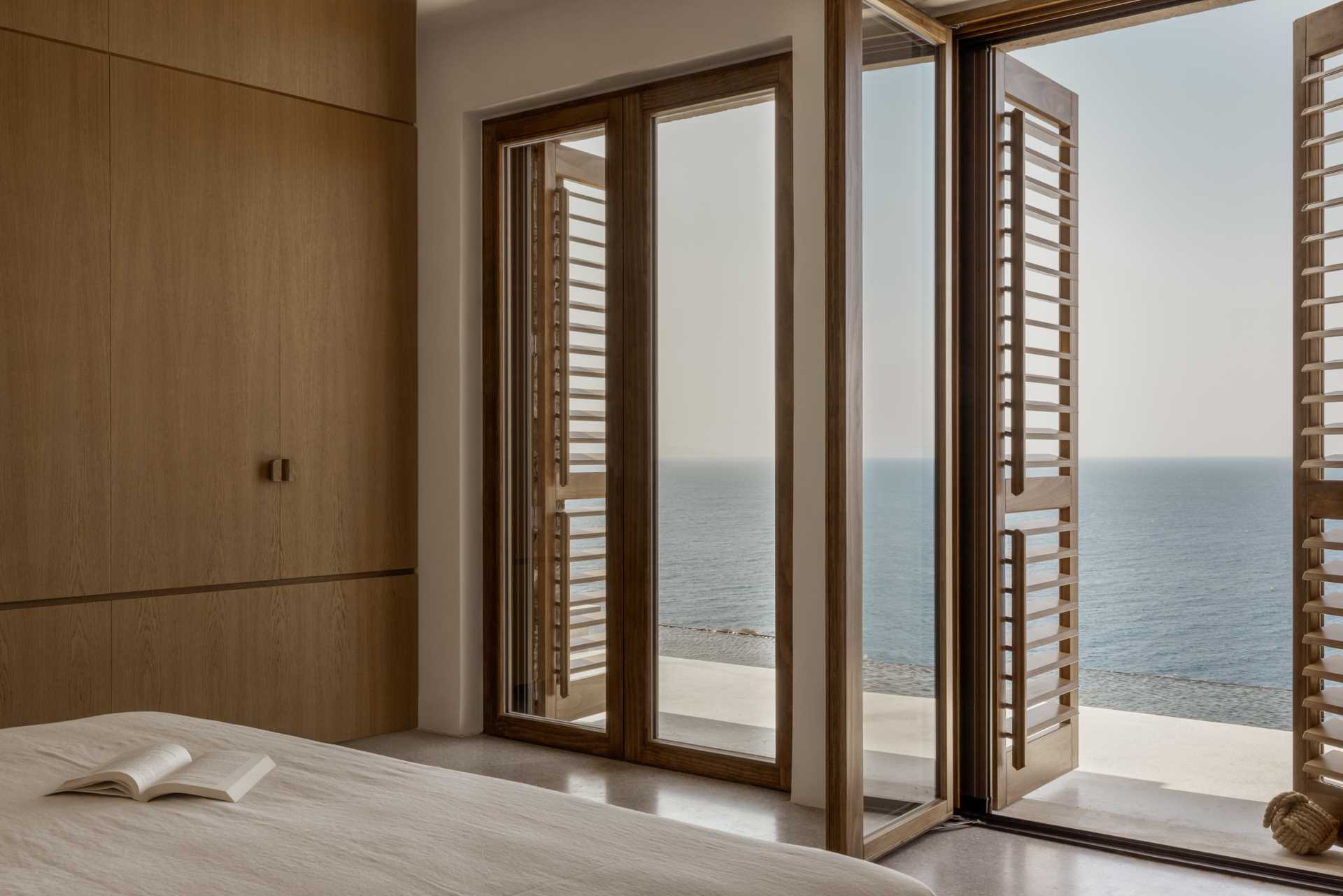 A modern bedroom with doors that open to a terrace.