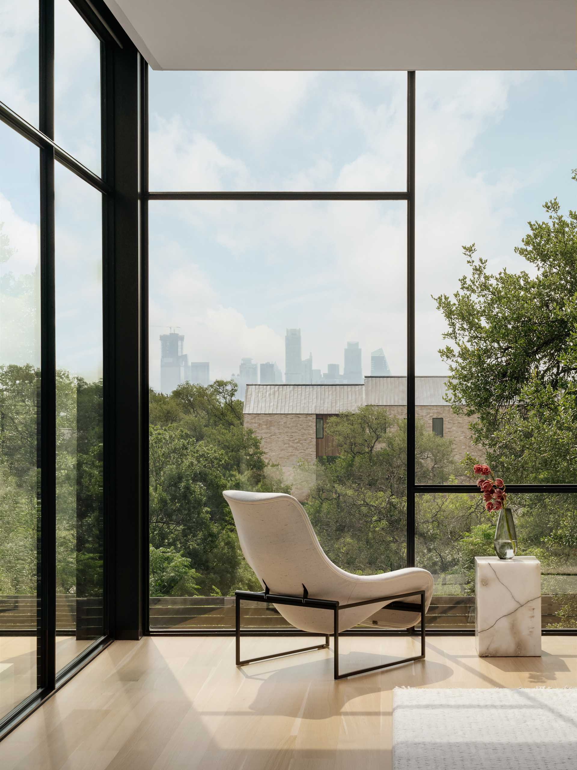 The primary suite is cantilevered above the sloping grade and is the closest part of the residence to the city, allowing the bedroom to essentially float among the treetops while hovering above the adjacent pool.