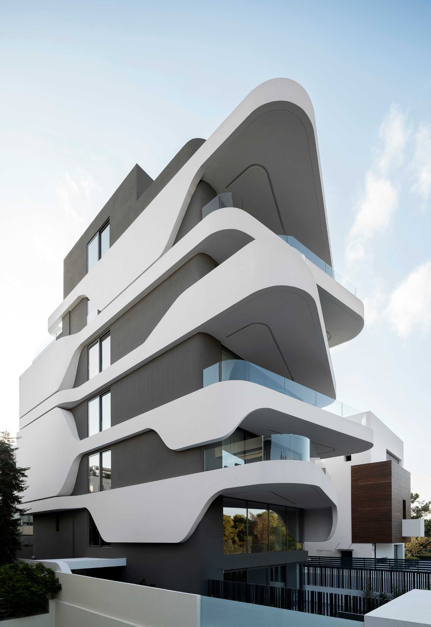 Key to the design of this modern apartment building are the curvilinear balconies that alternate directions creating a lively facade.