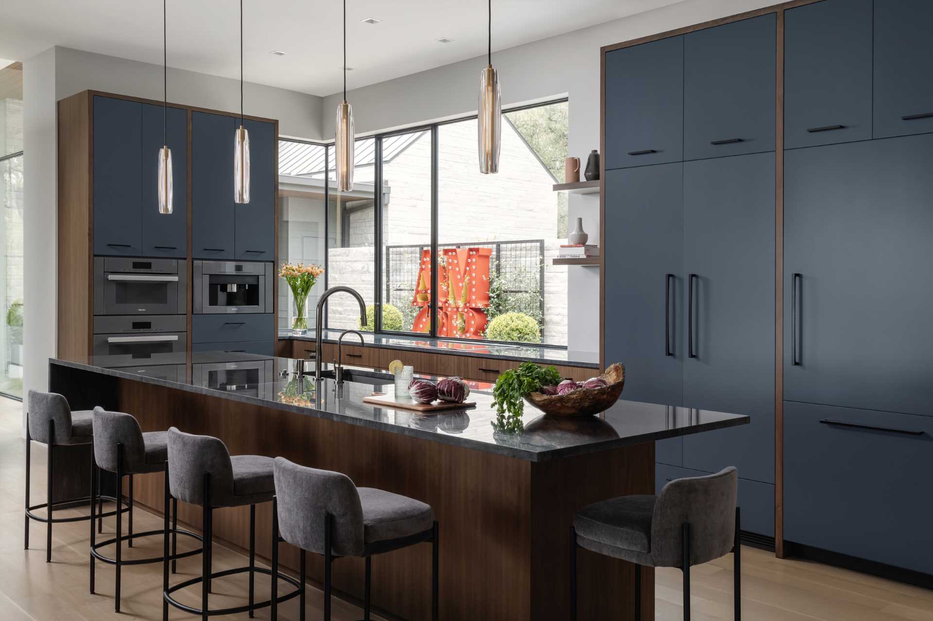 In this modern kitchen, deep walnut tones and a Diamante Nero quartzite create a bold appearance.