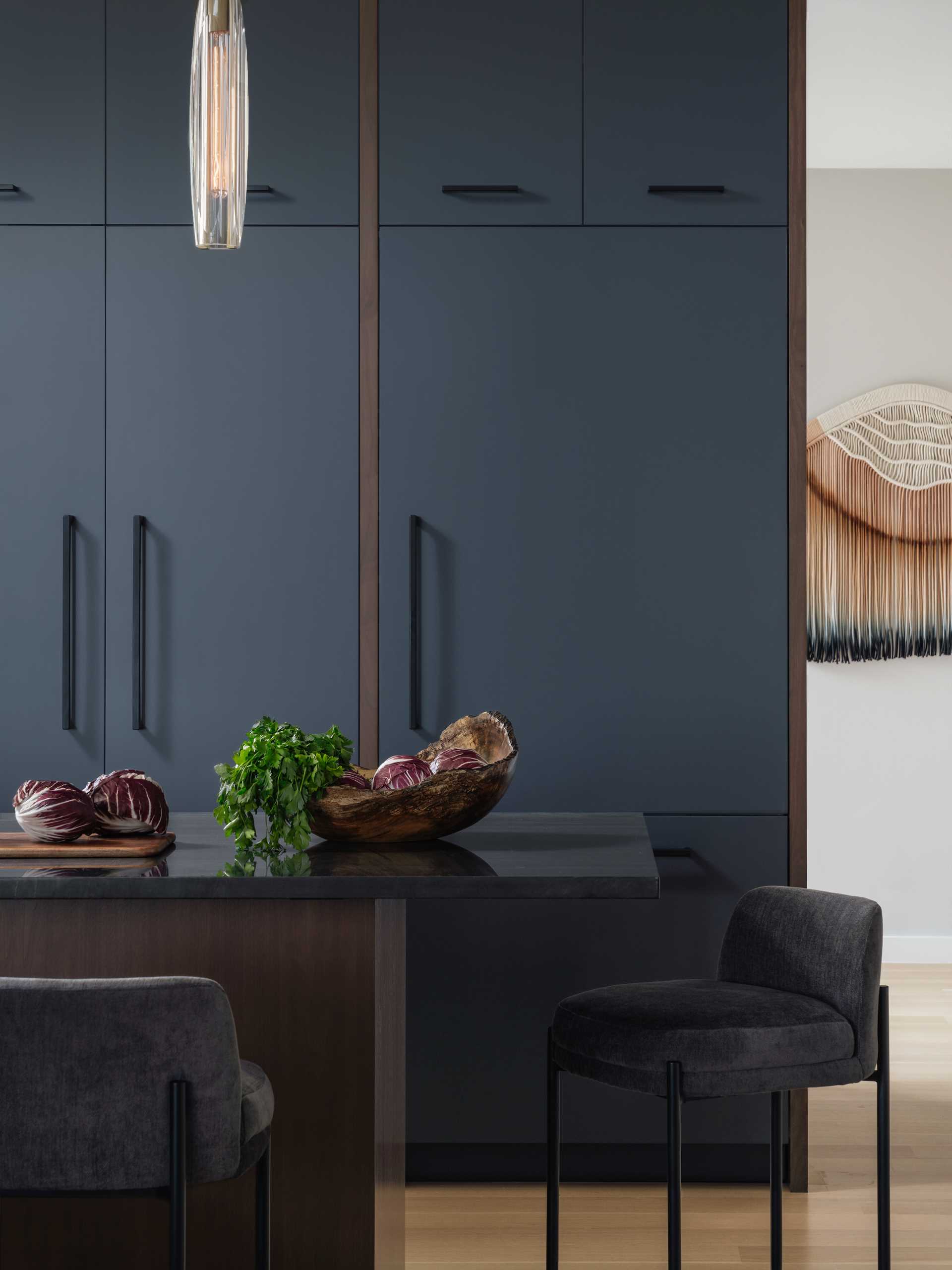 In this modern kitchen, deep walnut tones and a Diamante Nero quartzite create a bold appearance.