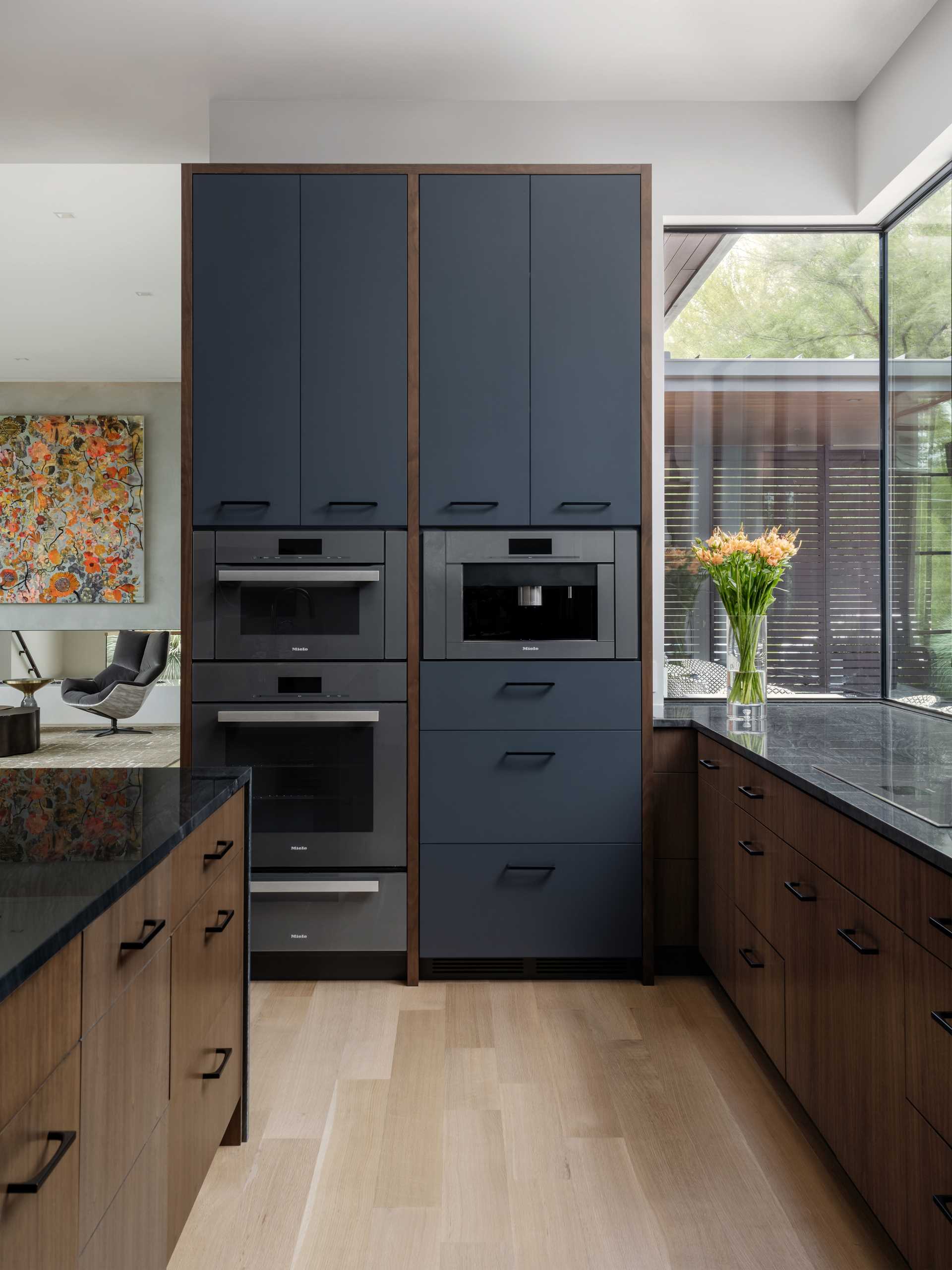 In this modern kitchen, deep walnut tones and a Diamante Nero quartzite create a bold appearance.