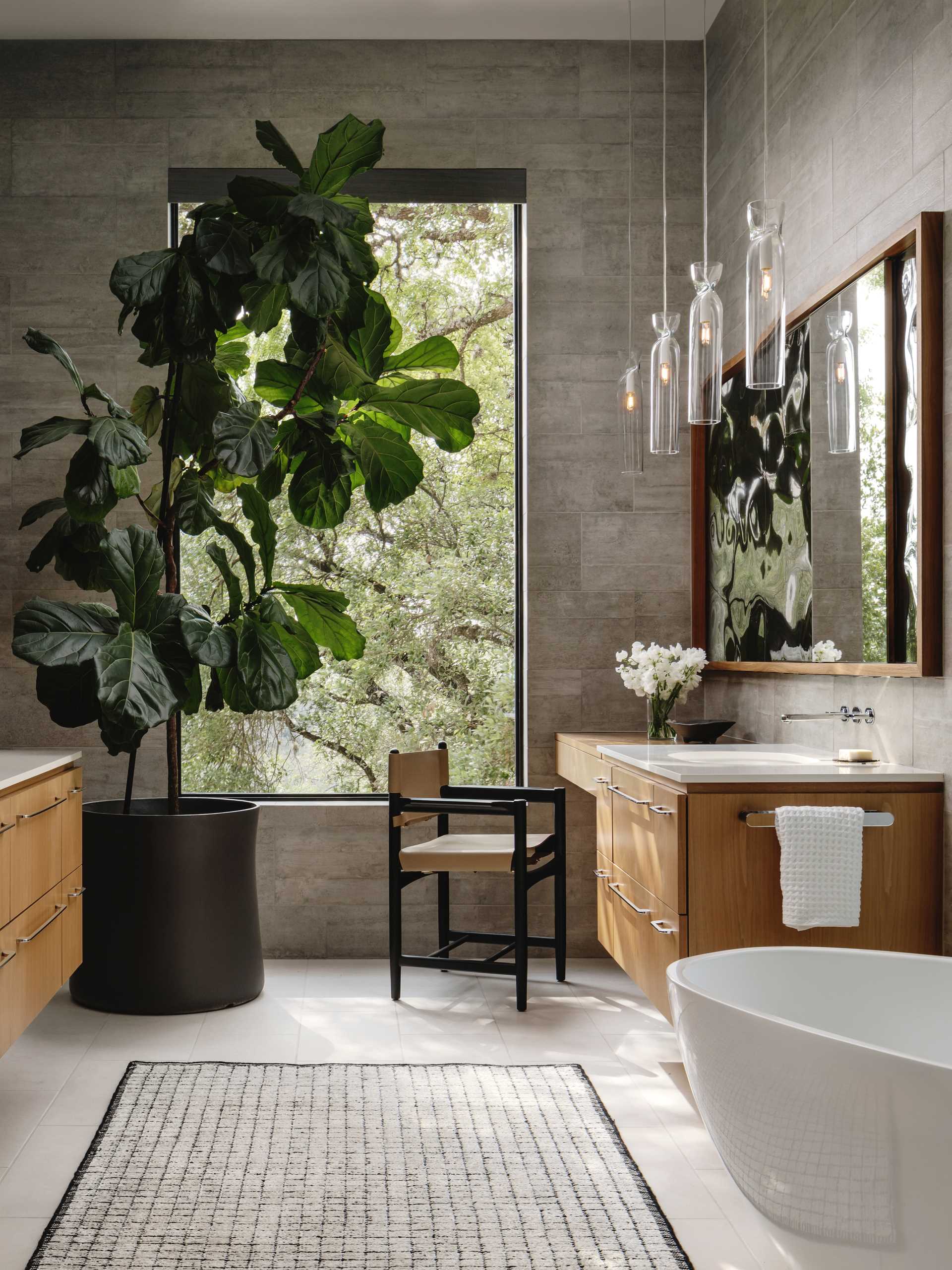 In one of the bathrooms, vanities are featured on each wall, while a large window adds natural light.