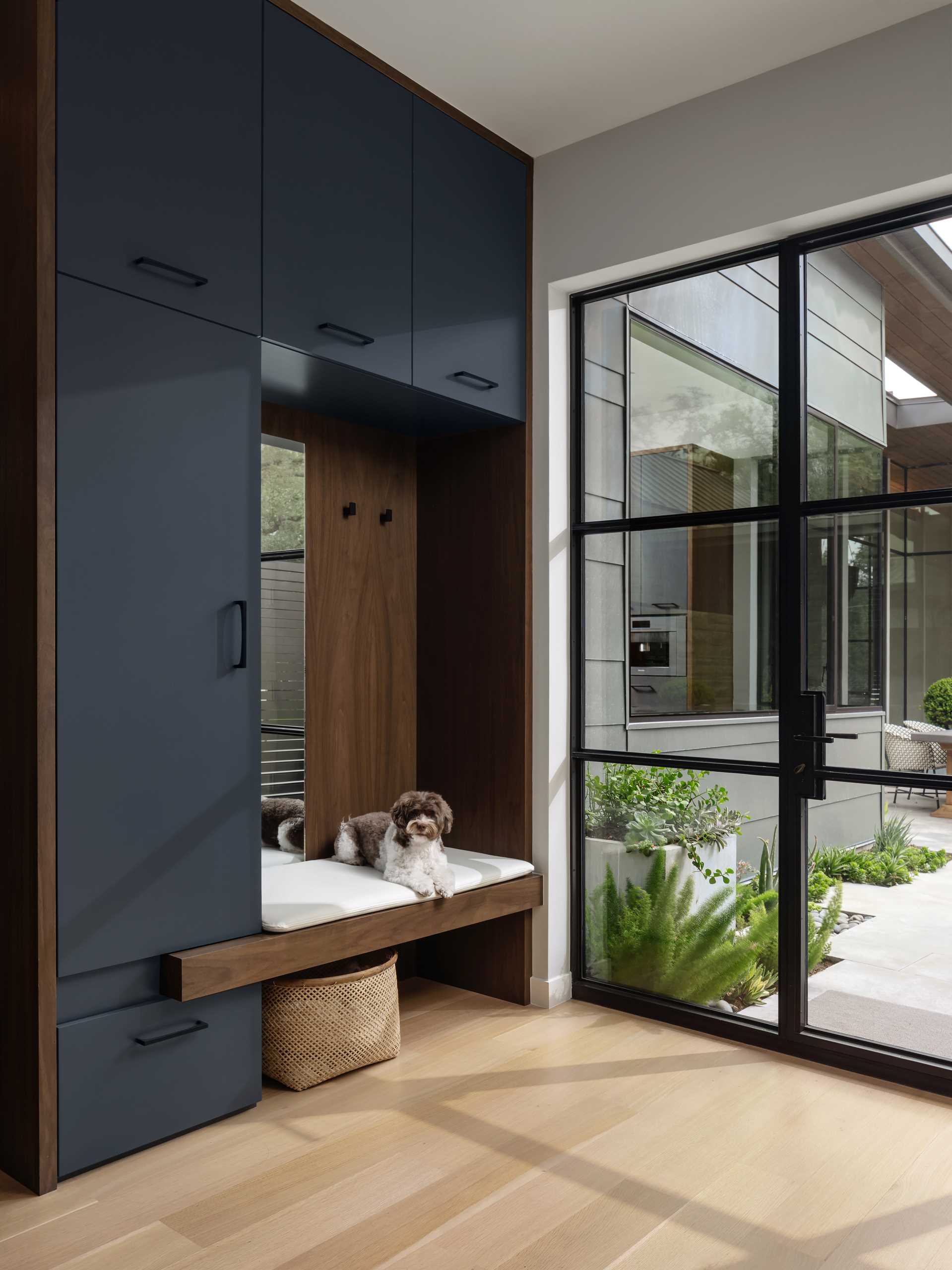 This entryway features built-in cabinetry and a bench with a mirror.