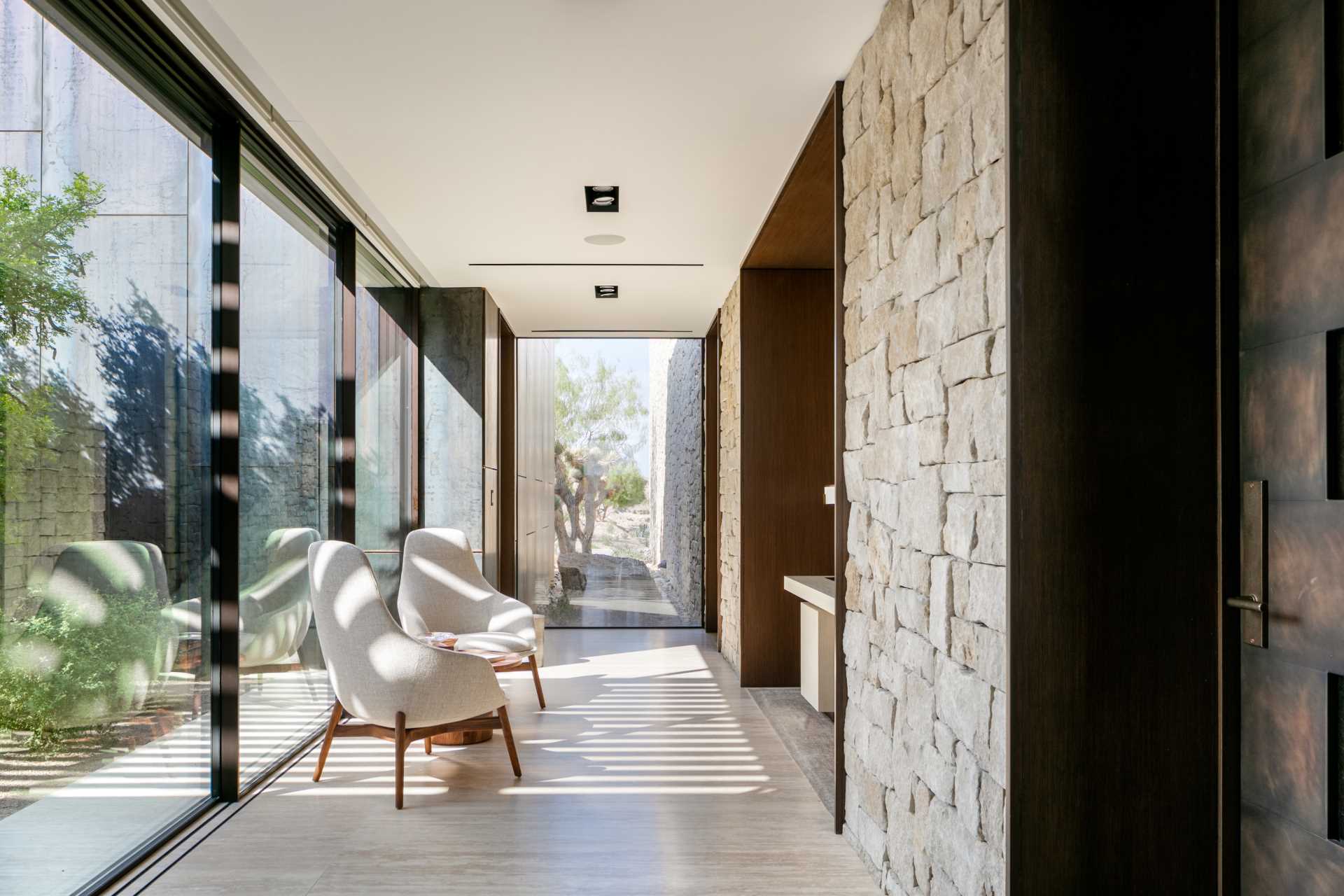 Floor-to-ceiling windows in a hallway frame the views and provide ample natural light to the interior spaces.