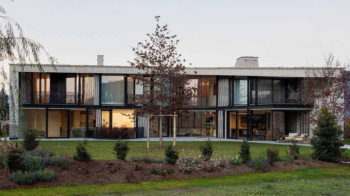 A modern home features one side with plenty of windows.