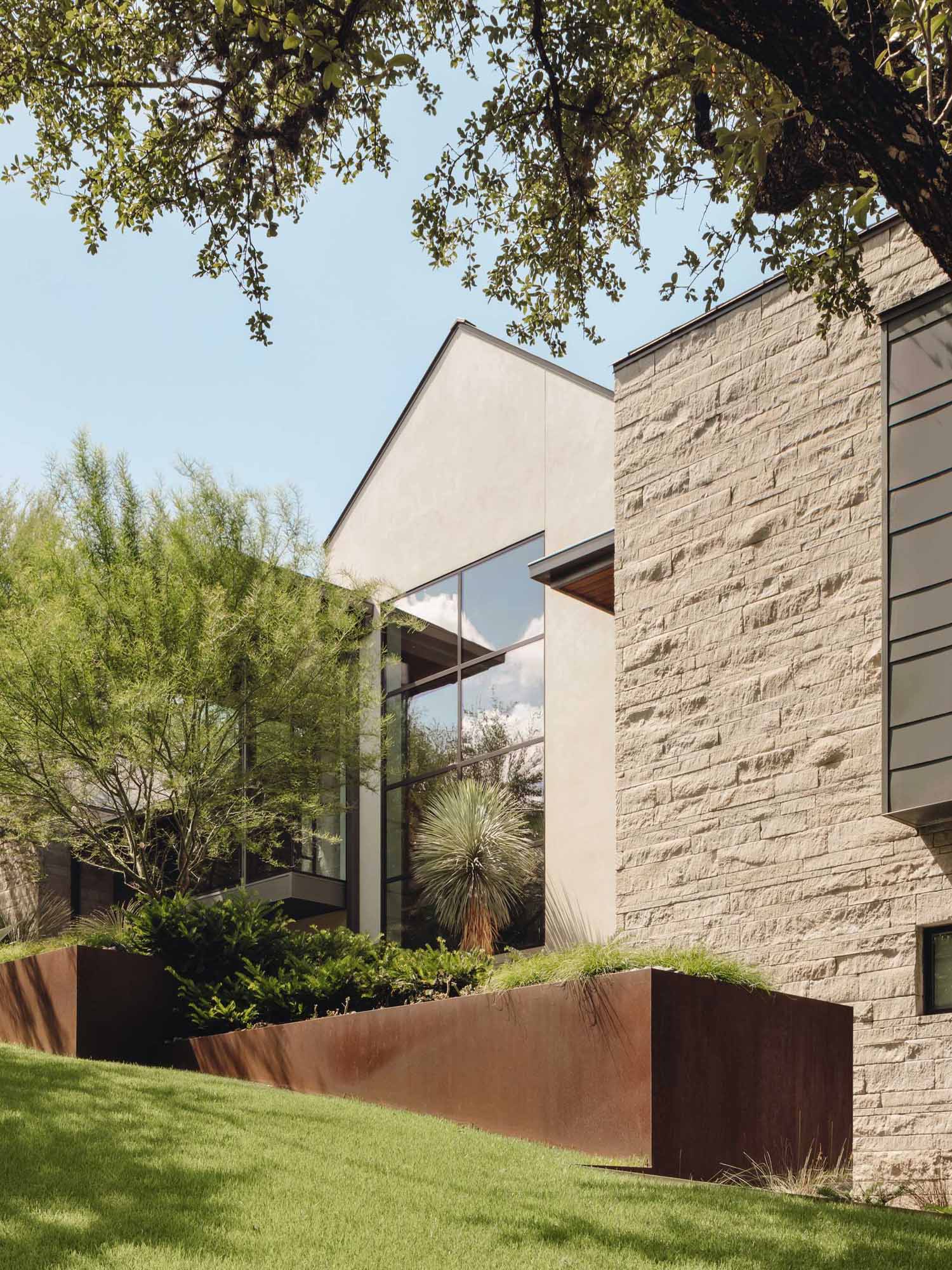 A modern home with an H-shaped layout that's composed of cantilevered boxes and gabled forms.