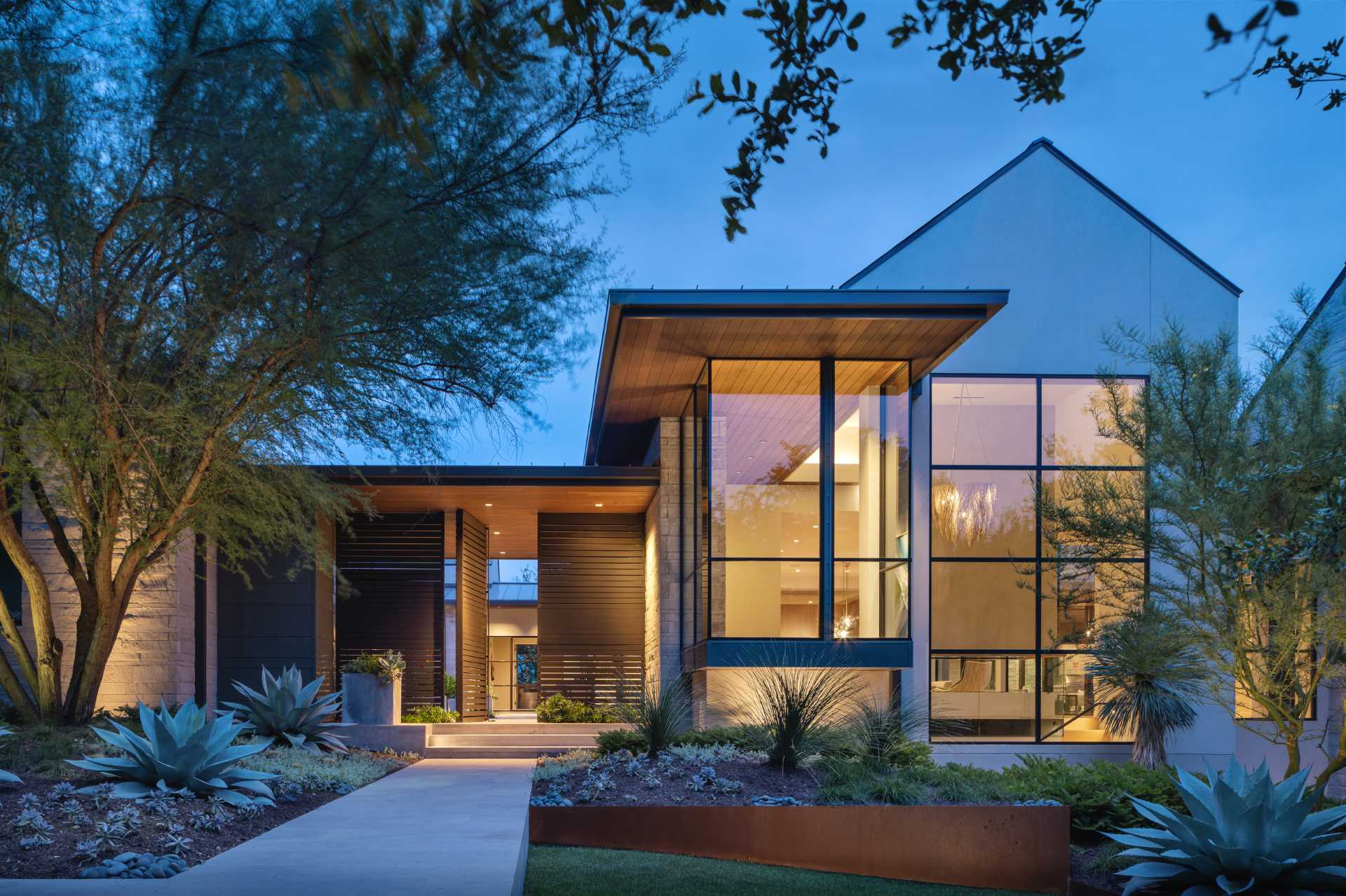 A modern home with an H-shaped layout that's composed of cantilevered boxes and gabled forms.