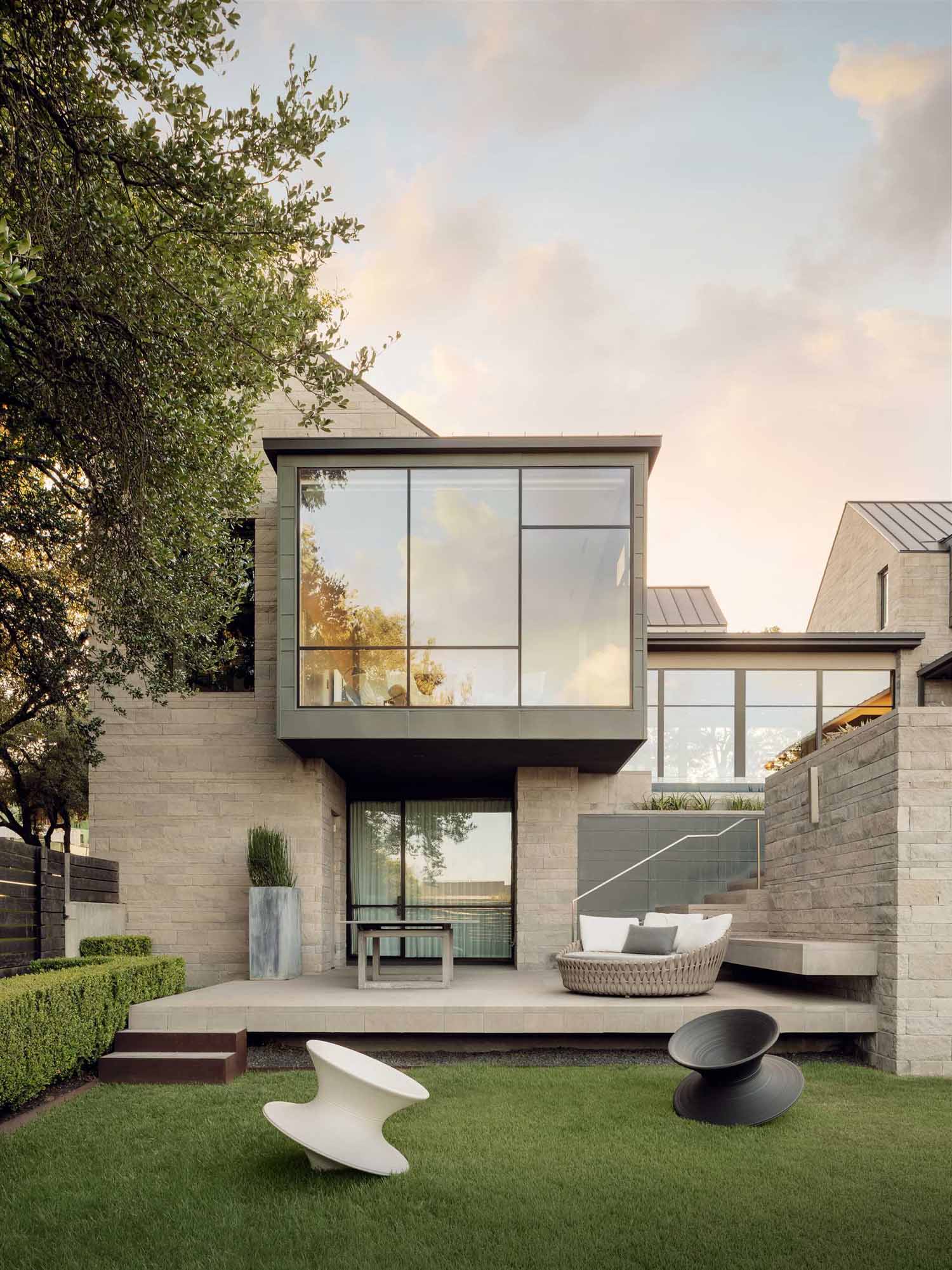 A modern home with an H-shaped layout that's composed of cantilevered boxes and gabled forms that wrap around a swimming pool.