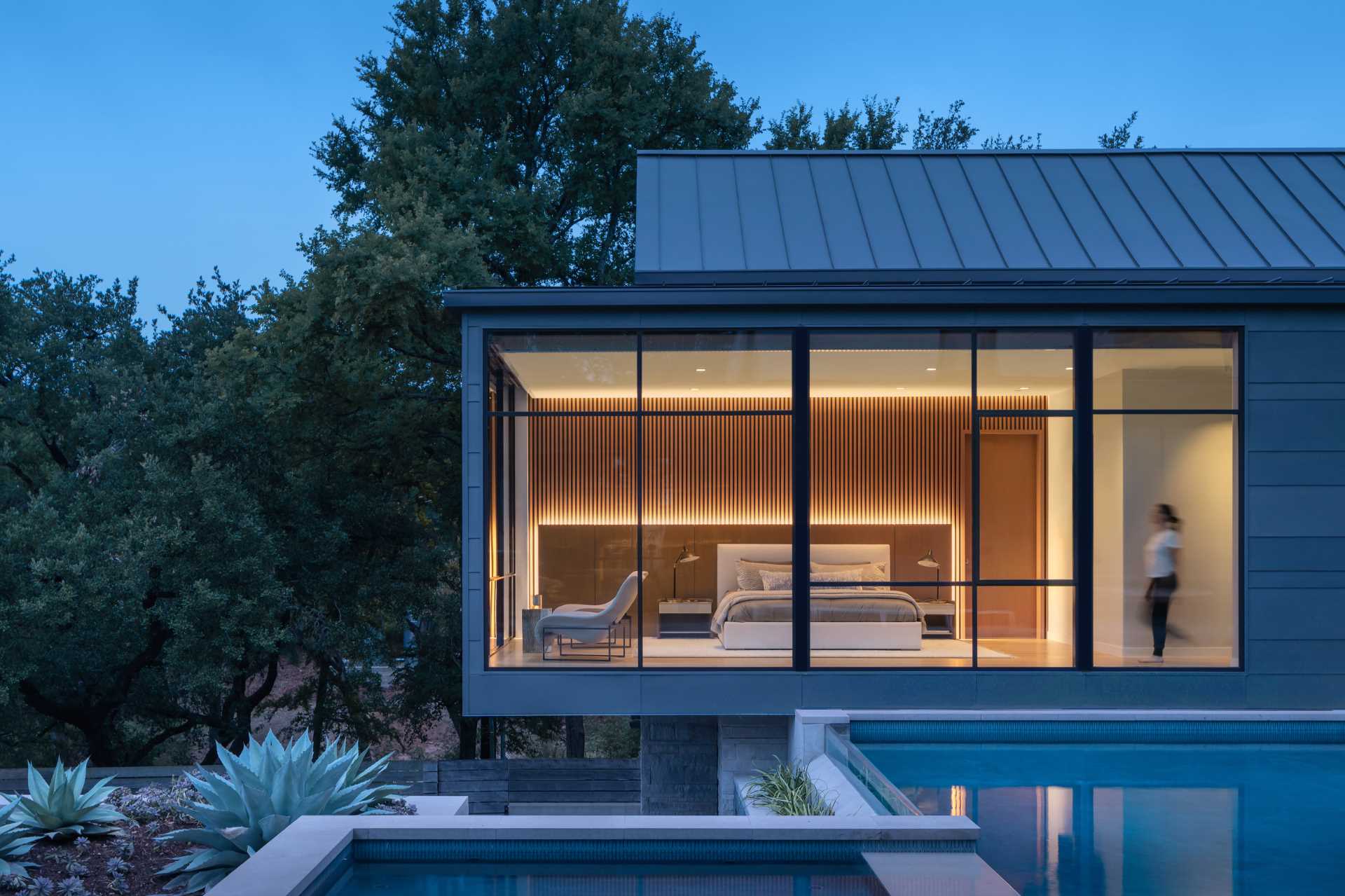 A modern home with an H-shaped layout that's composed of cantilevered boxes and gabled forms that wrap around a swimming pool.