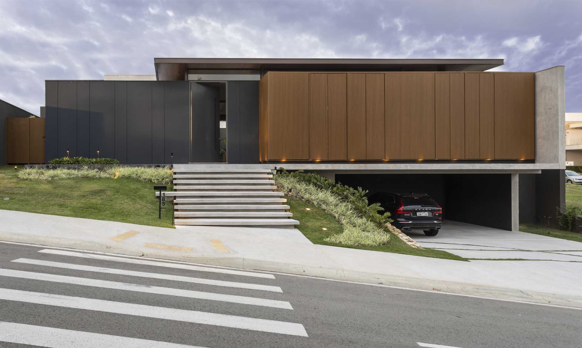 The home has been designed in such a way that the interior is hidden from the street. The front door blends into the black and wood facade.