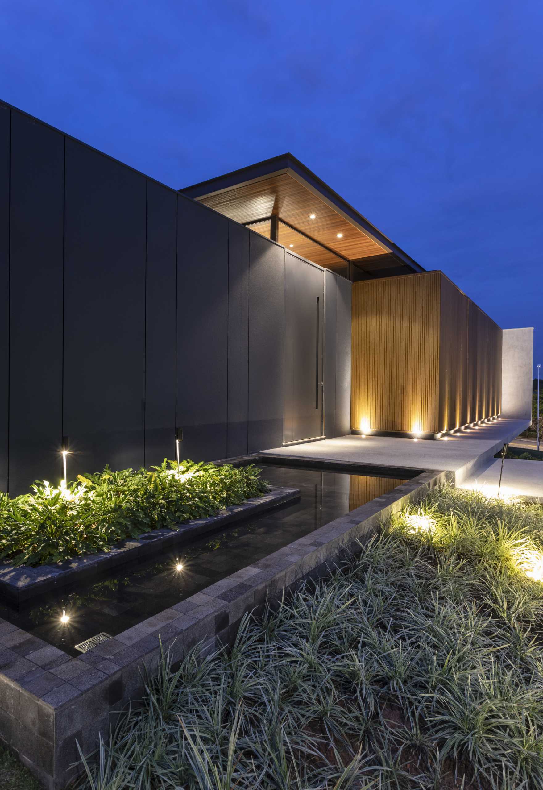 The home has been designed in such a way that the interior is hidden from the street. The front door blends into the black and wood facade.