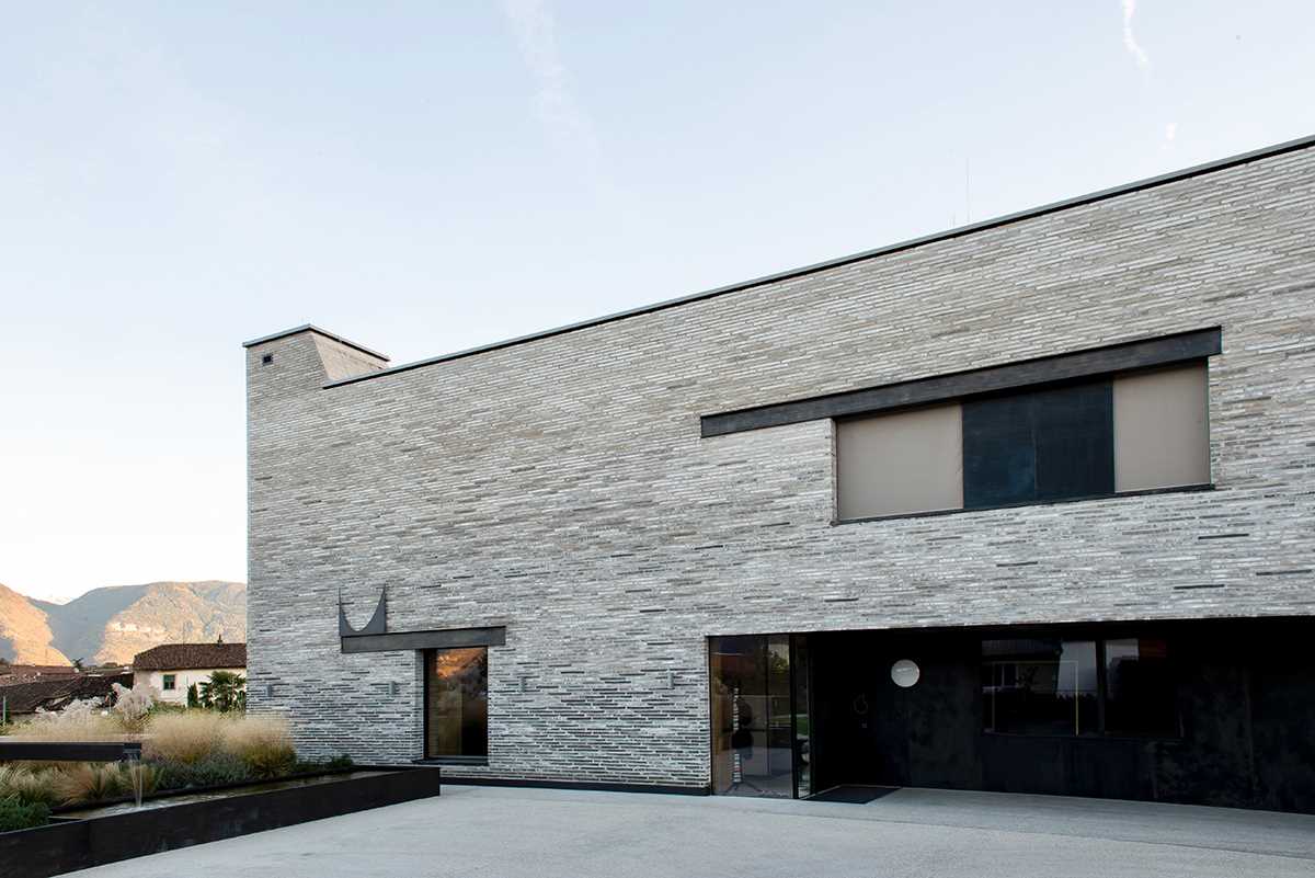 A modern home features handmade elongated bricks ranging from dark to light.