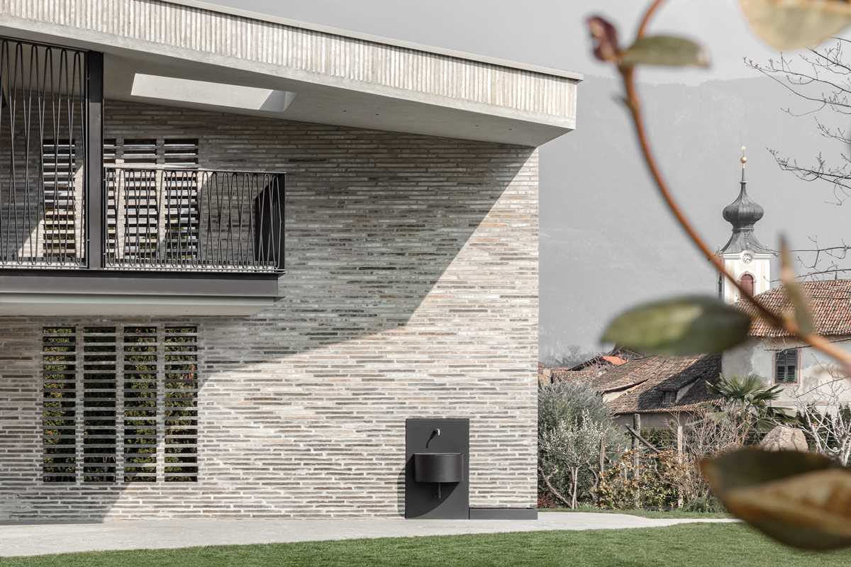 A modern home features handmade elongated bricks ranging from dark to light.