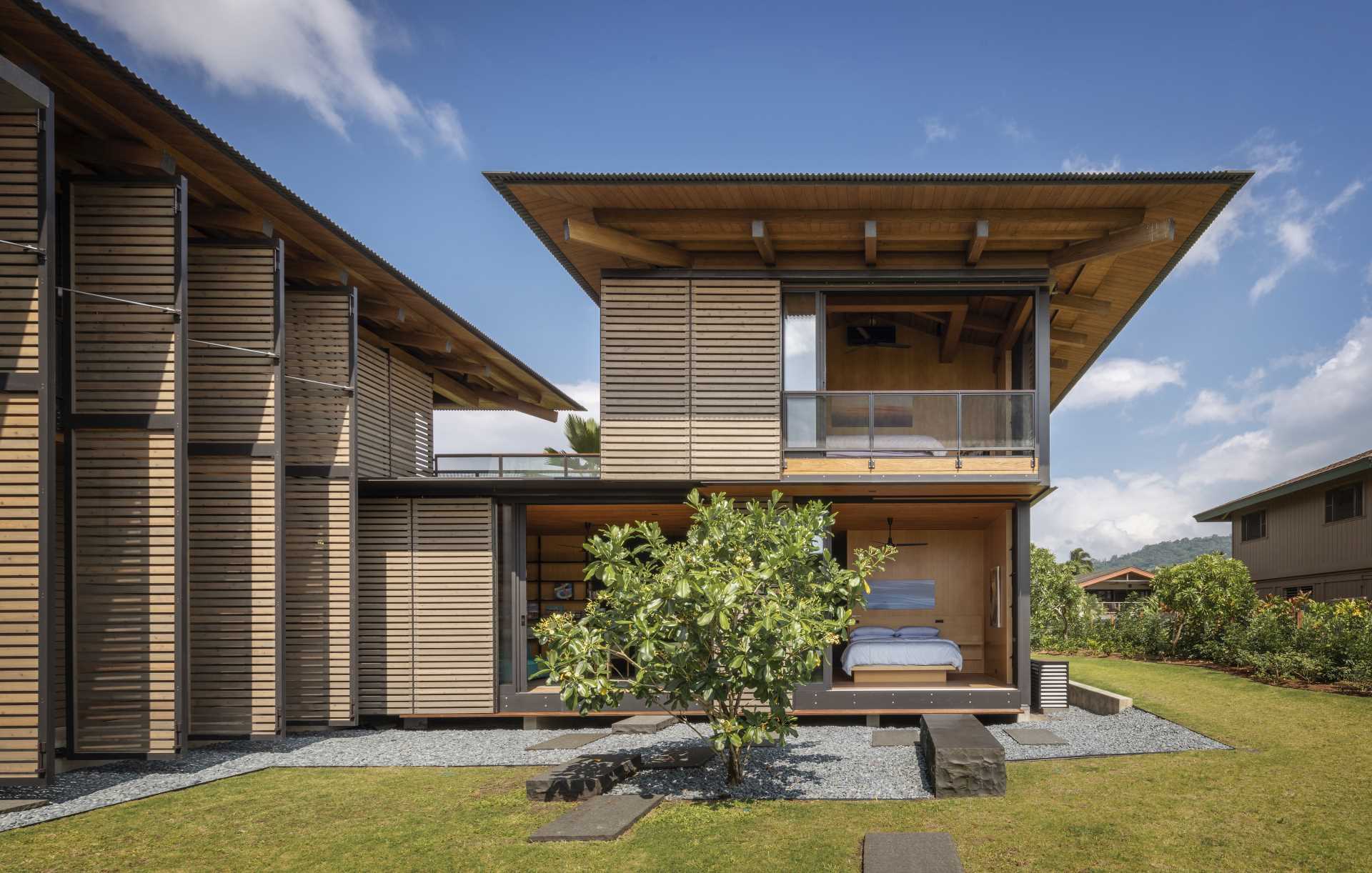 A modern home includes a series of operable shutter screens that wrap most of the building facade.