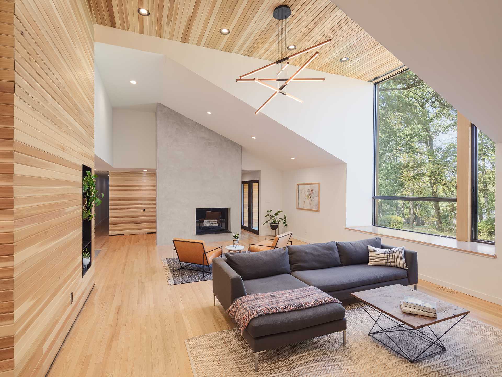 A cedar-clad accent in this living room wraps from the wall to the ceiling and includes steel-lined pass-through shelving.