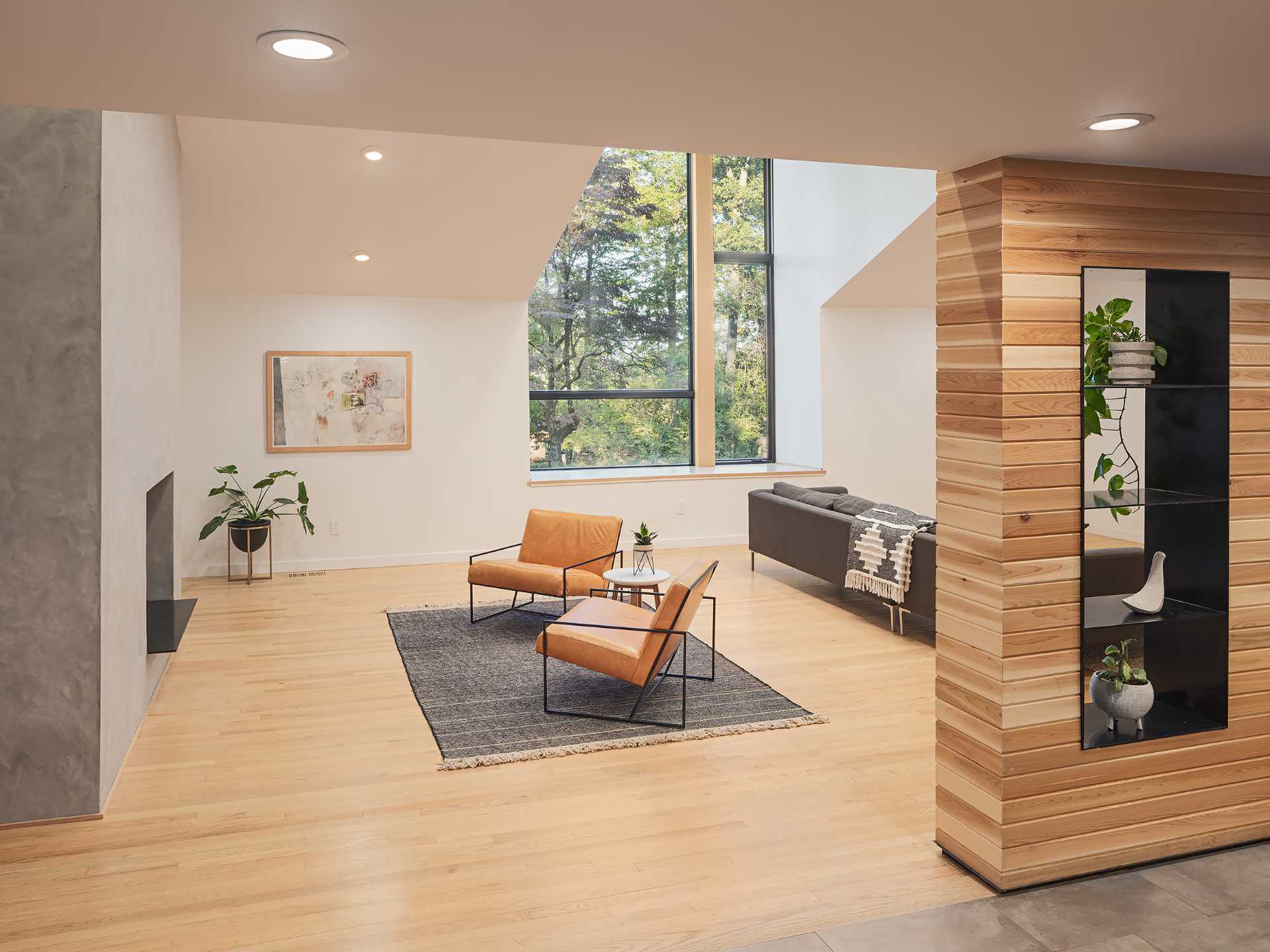 A cedar-clad accent in this living room wraps from the wall to the ceiling and includes steel-lined pass-through shelving.