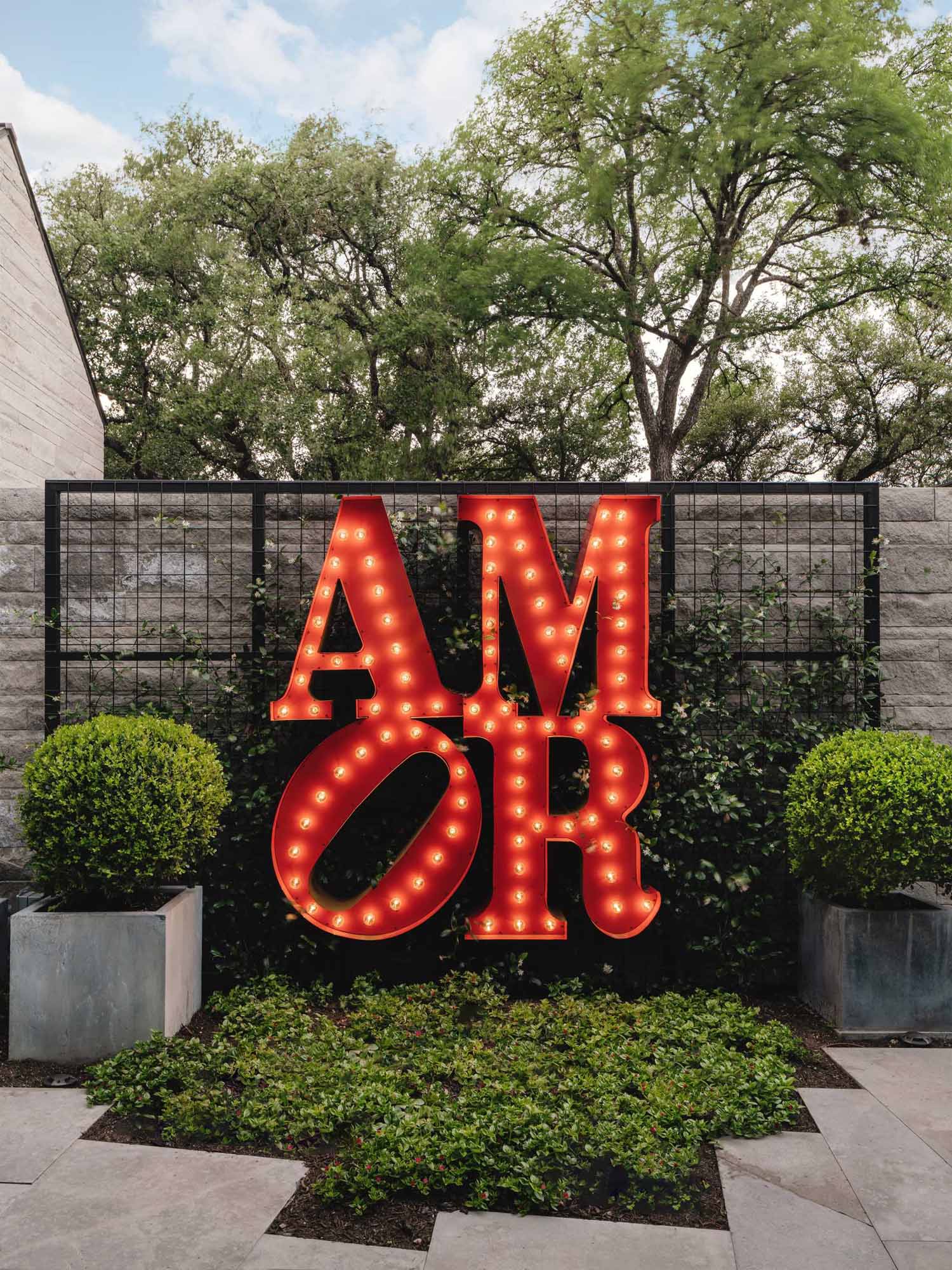 A discreet courtyard leads into the main house and features a bistro dining area and a custom ‘amor’ metal sign (inspired by the original iconic sculpture by Robert Indiana).