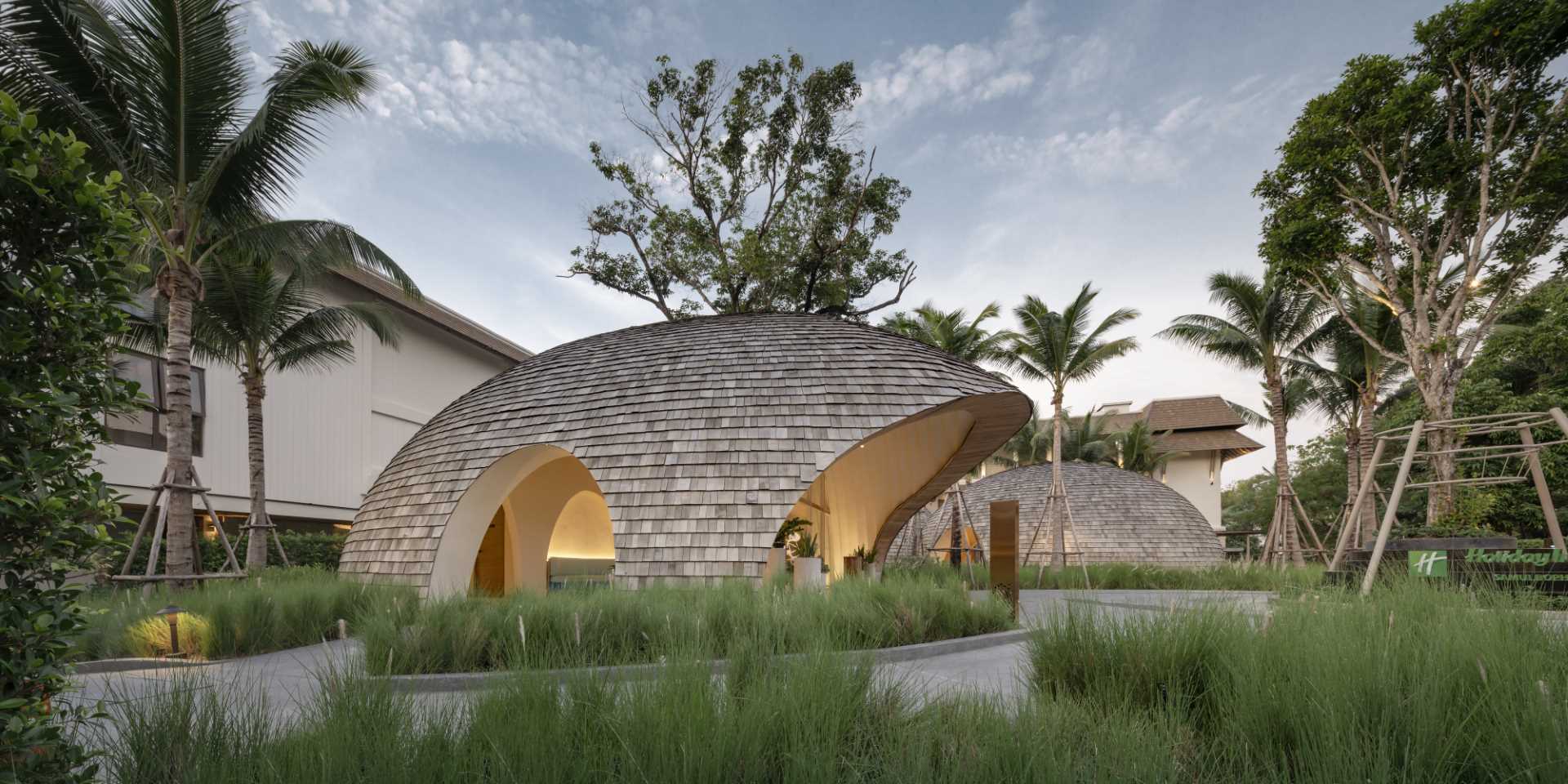 A modern hotel lobby whose design is inspired by the shape and interior of a coconut, and features a shingle-clad exterior.
