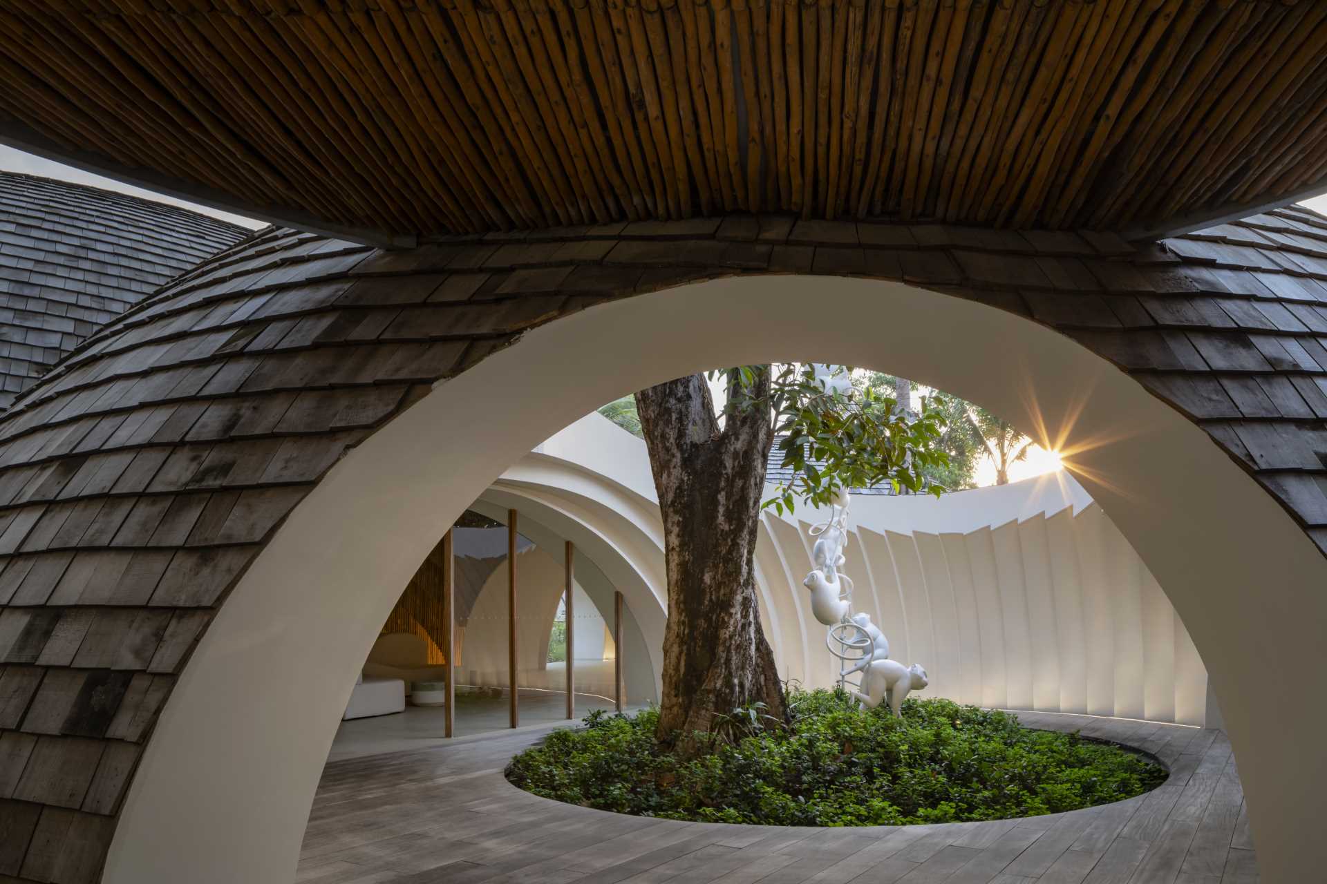 A modern hotel lobby whose design is inspired by the shape and interior of a coconut, and features a shingle-clad exterior.