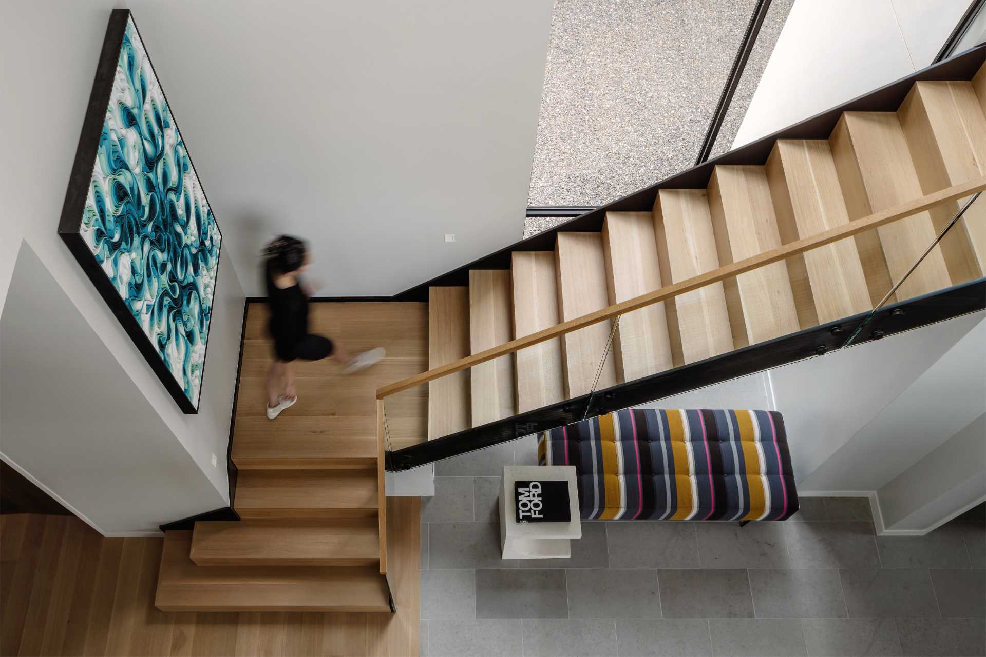 Metal and wood stairs connect the various levels of the home, while a seating area has been added underneath.